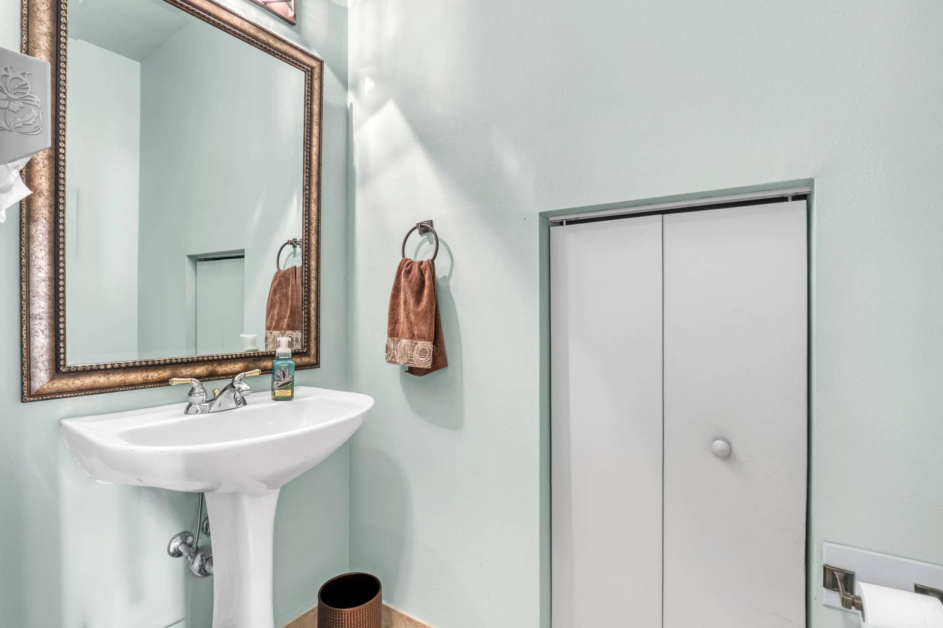 762 GAZETTA Way, West Palm Beach, FL 33413 White pedestal sink with a metallic dual-handle faucet and bi-fold closet doors