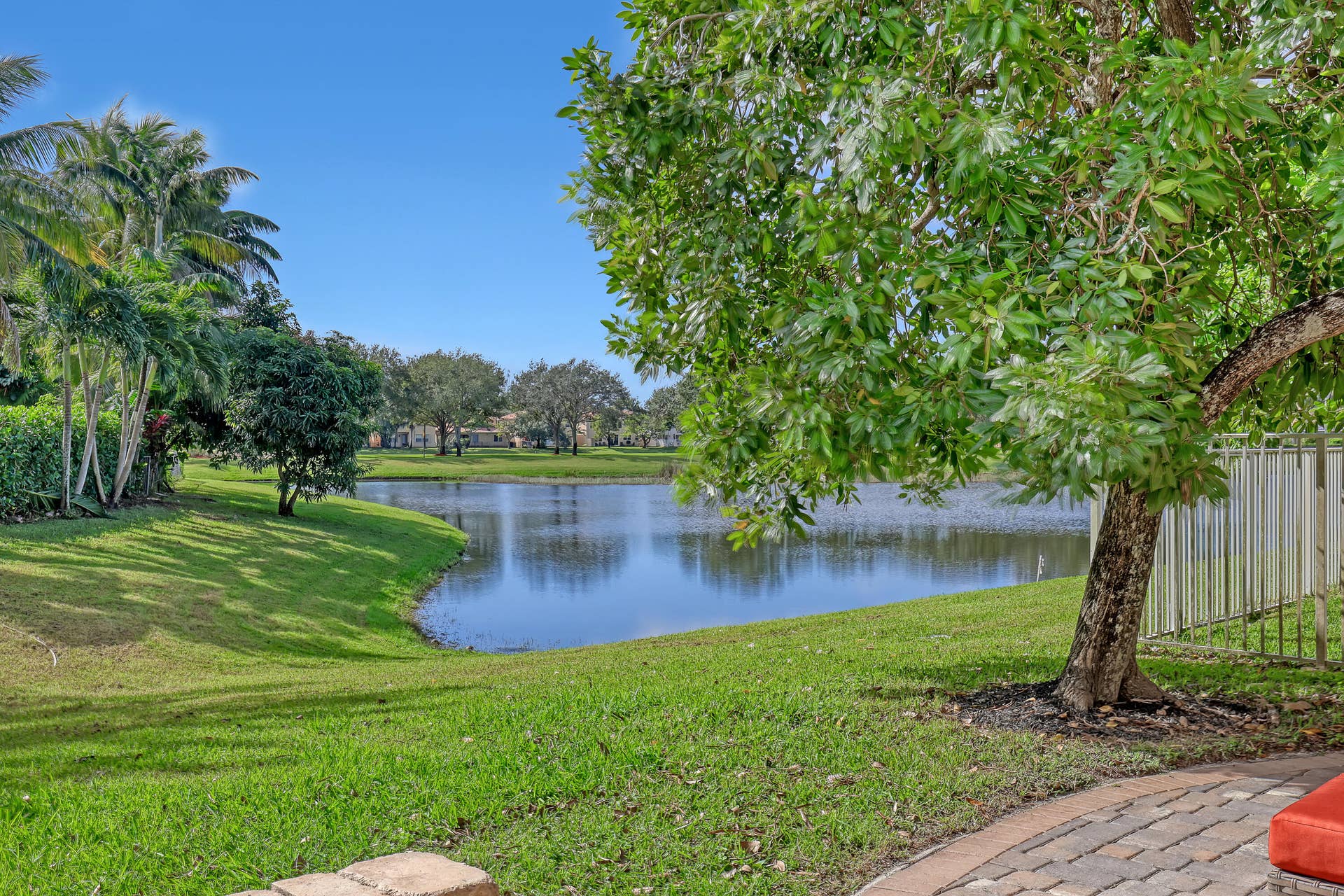 762 GAZETTA Way, West Palm Beach, FL 33413 Paver patio, expansive green space, mature trees, and a water feature
