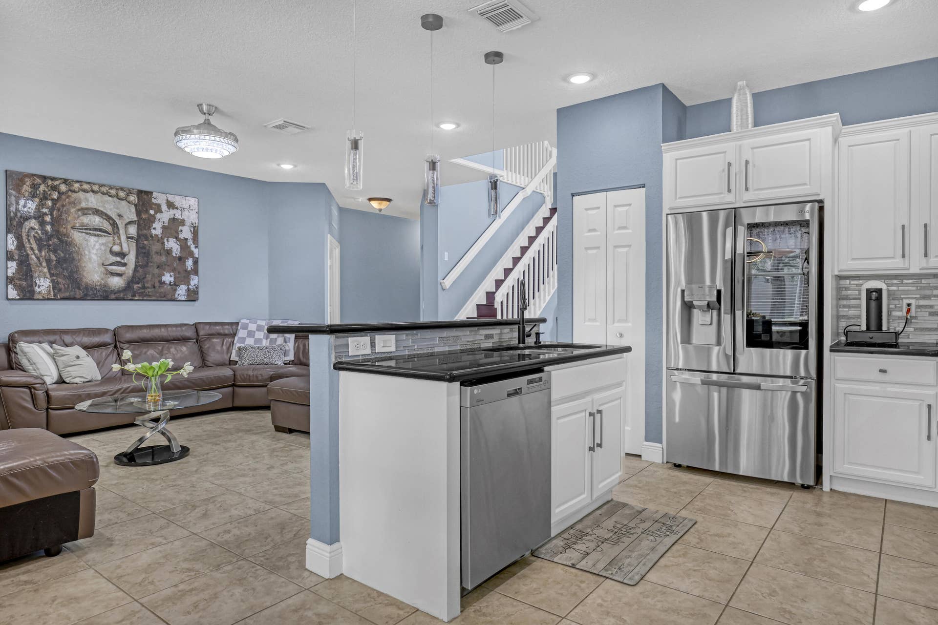 762 GAZETTA Way, West Palm Beach, FL 33413 Kitchen island featuring a granite countertop, white shaker-style cabinetry, stainless steel appliances, tile flooring, and multi-pendant lighting