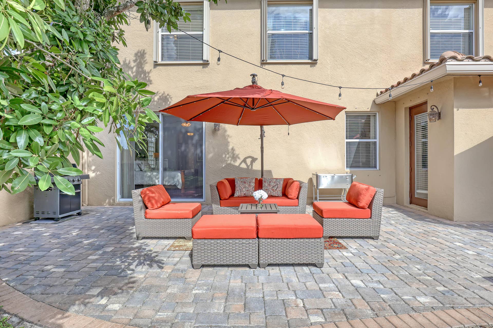 762 GAZETTA Way, West Palm Beach, FL 33413 Stucco exterior patio featuring multi-tonal paver hardscaping, and dual entry points via a sliding glass door and a glass-paneled side door