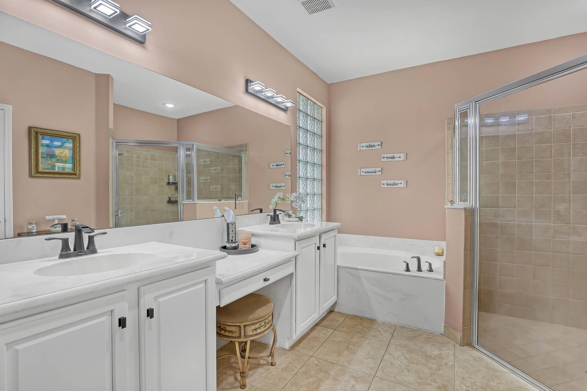 762 GAZETTA Way, West Palm Beach, FL 33413 Dual-sink vanity with white cabinetry and stone countertops, glass block window, soaking tub, and a walk-in shower with glass enclosure