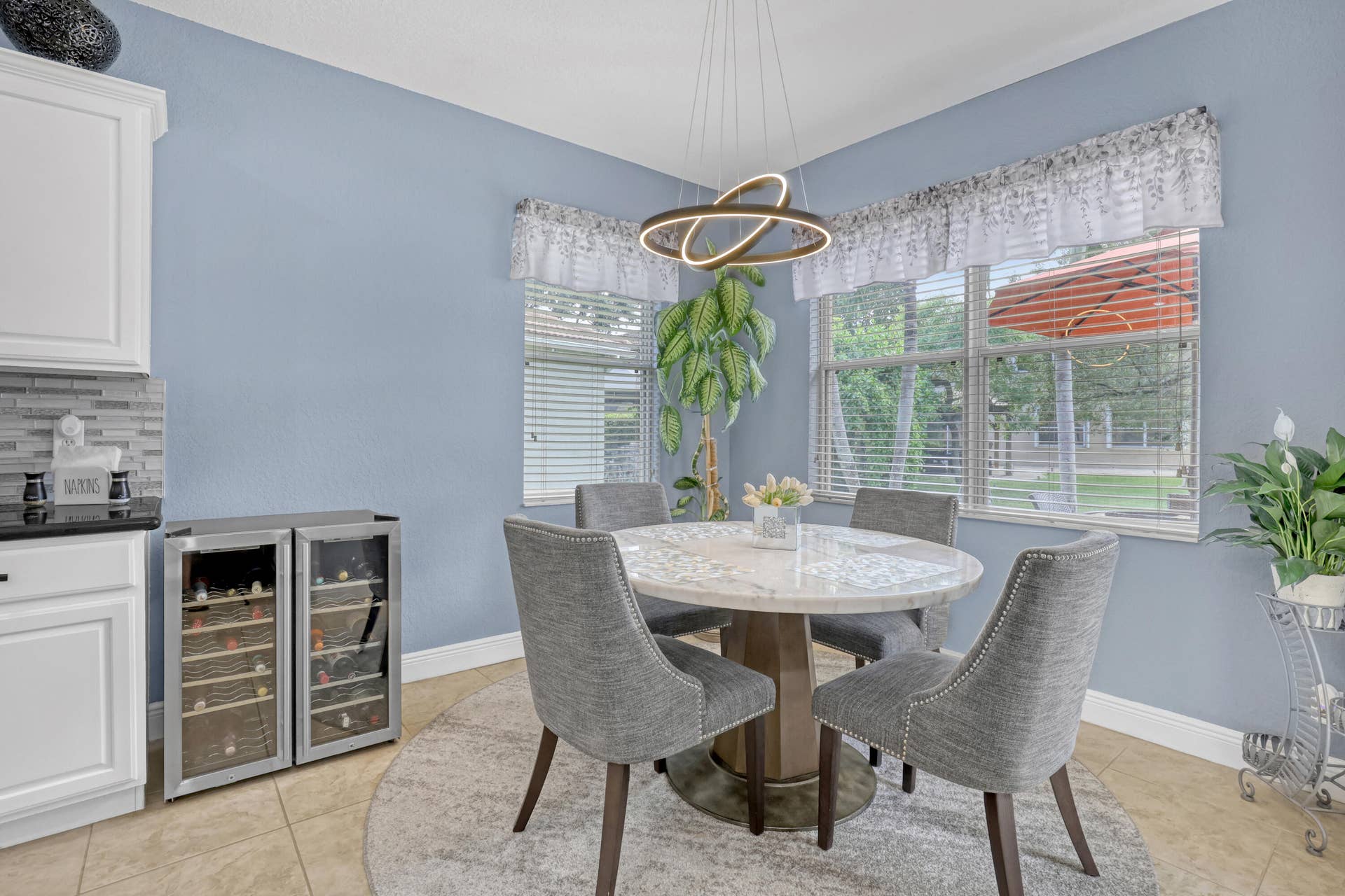 762 GAZETTA Way, West Palm Beach, FL 33413 Modern circular LED chandelier, white cabinetry, tile flooring, and multi-pane windows