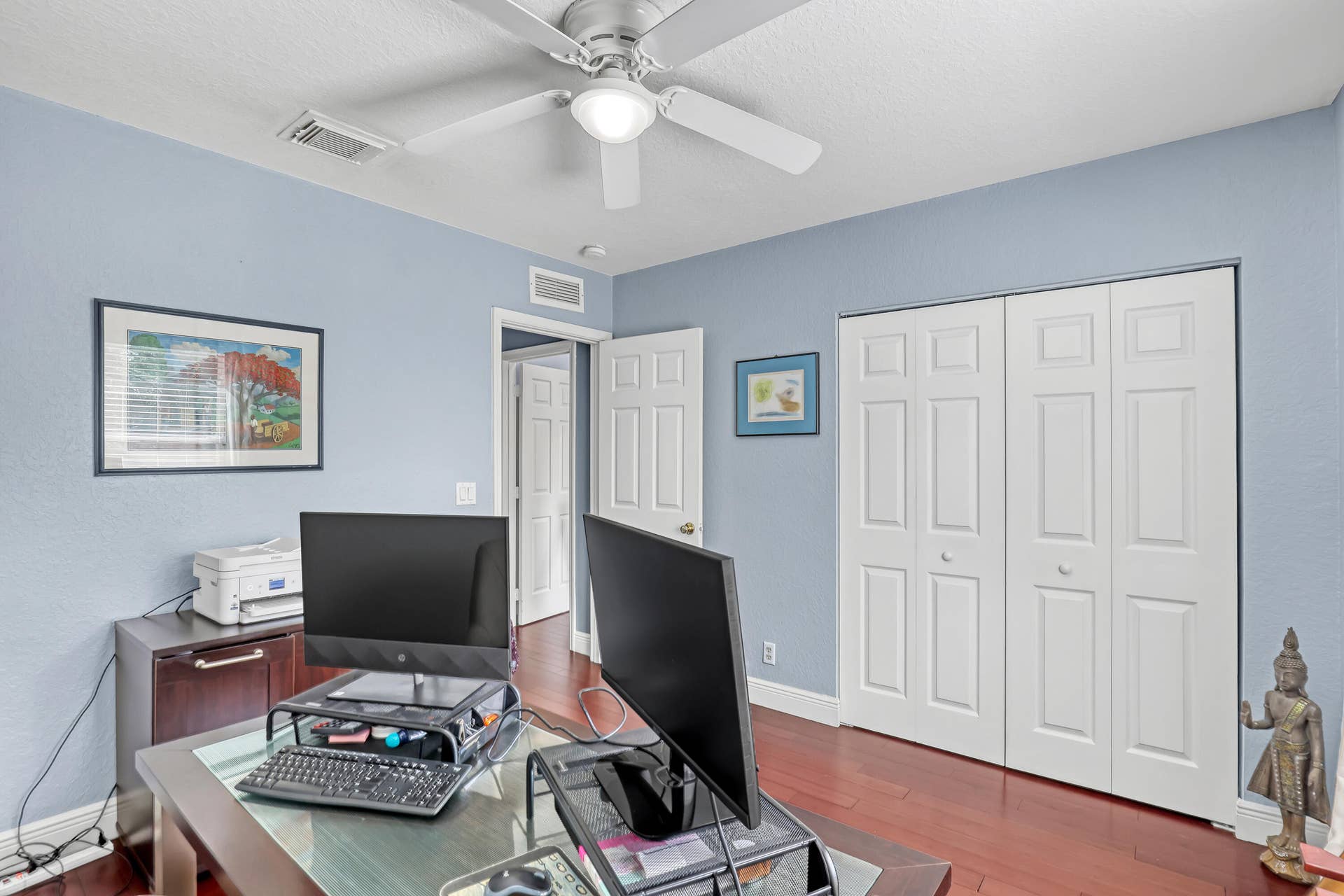 762 GAZETTA Way, West Palm Beach, FL 33413 Room featuring wood-finish flooring, a white ceiling fan with integrated lighting, and a double-door closet with raised-panel detailing