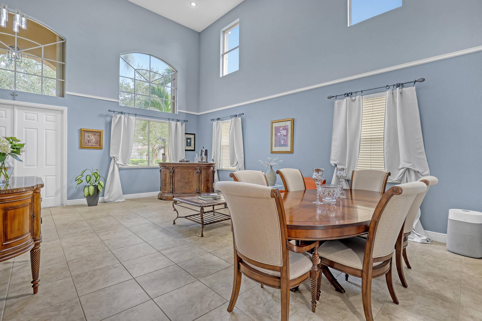 762 GAZETTA Way, West Palm Beach, FL 33413 High-ceiling living area featuring tile flooring, expansive arched windows, crisp wall molding, and recessed lighting