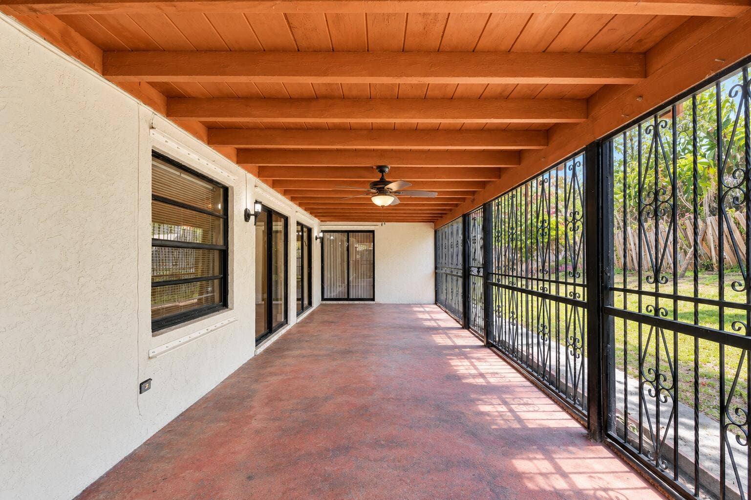 Expansive Covered Patio with Exposed Wood-Beam Ceiling, Ceiling Fan & Garden Views