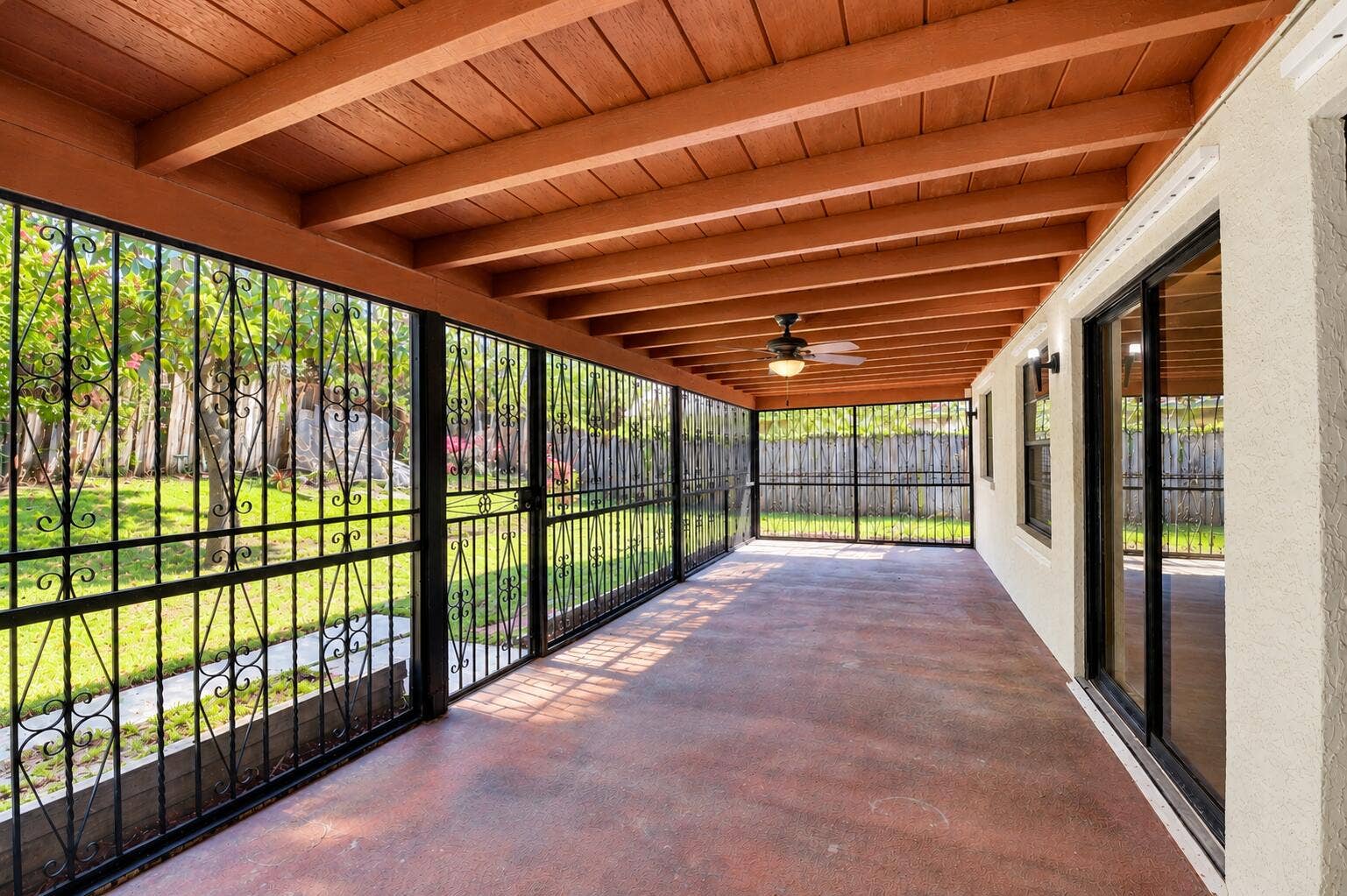 Expansive Covered Patio with Exposed Wood-Beam Ceiling, Ceiling Fan & Garden Views