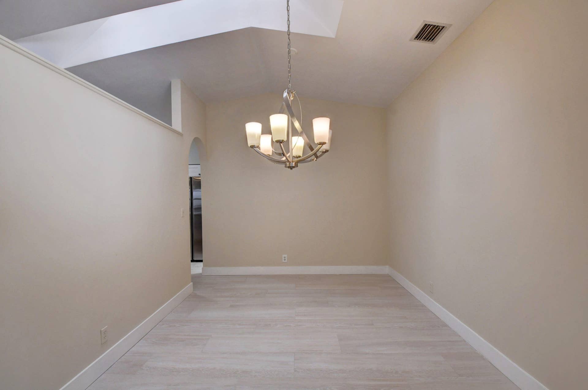 Elegant Dining Area with Chandelier & Vaulted Ceiling