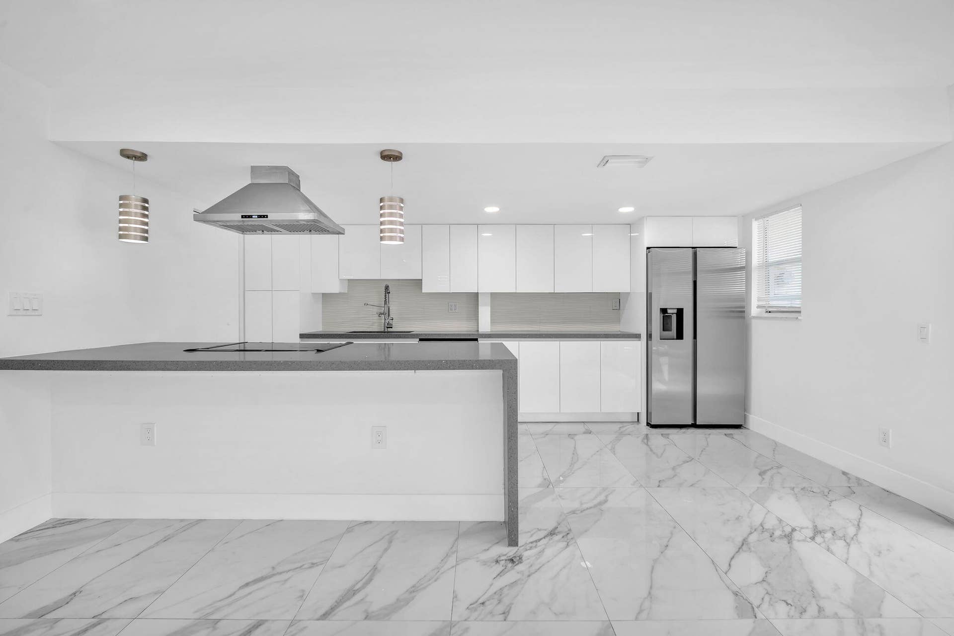 4162 SW 65th Avenue, #84, Davie, FL 33314 Kitchen featuring white flat-panel cabinetry, quartz countertops, a stainless steel range hood, stainless steel refrigerator, and stone-finish flooring