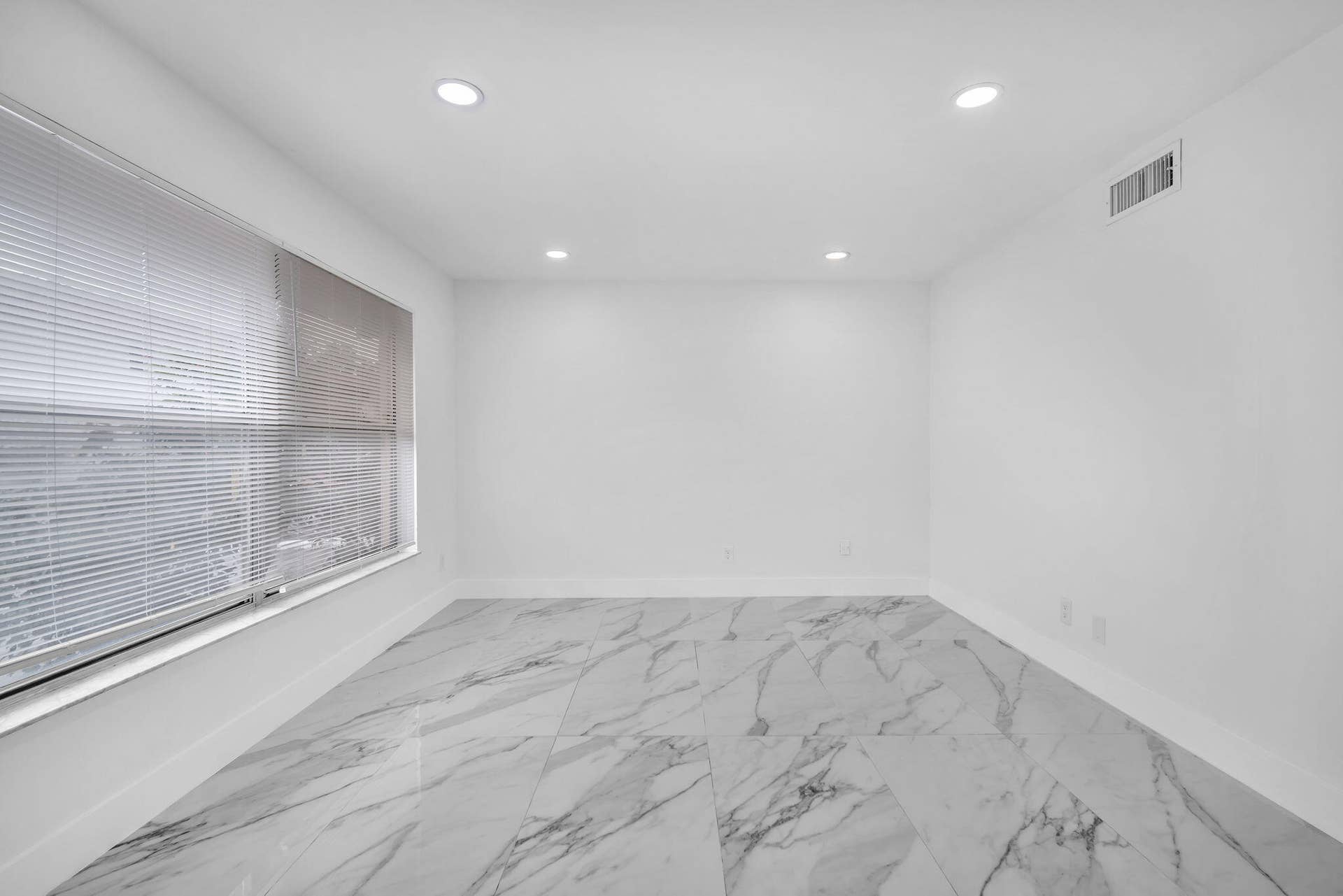 4162 SW 65th Avenue, #84, Davie, FL 33314 Interior space featuring large-format veined tile flooring, recessed ceiling lighting, and windows equipped with fitted horizontal blinds