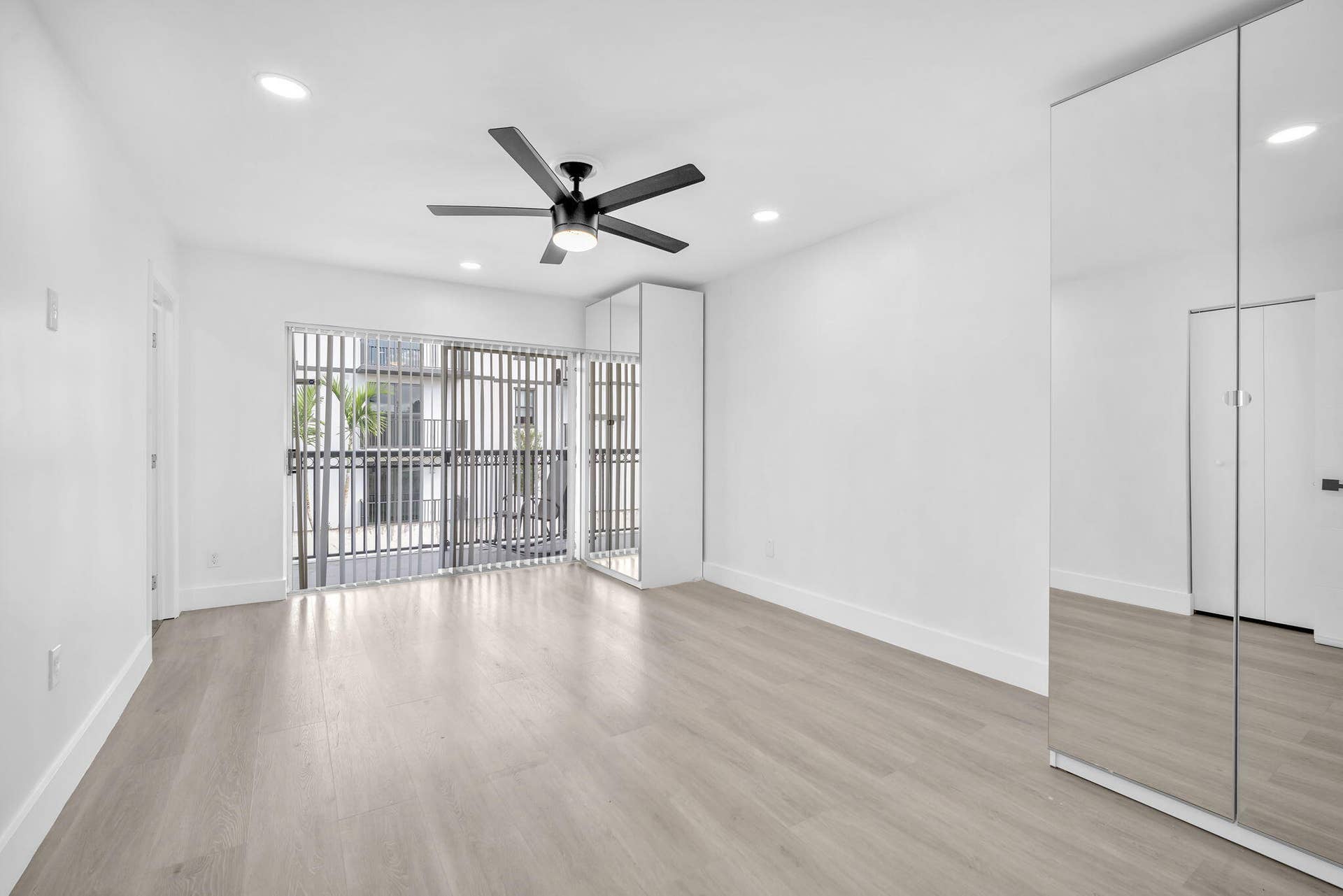 4162 SW 65th Avenue, #84, Davie, FL 33314 Light-filled room featuring wood-finish flooring, recessed lighting, a modern ceiling fan, and floor-to-ceiling mirrored closet doors