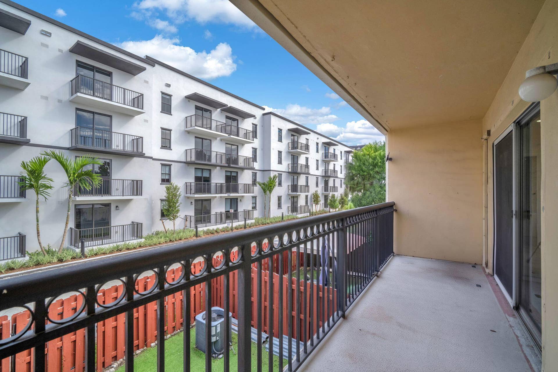 4162 SW 65th Avenue, #84, Davie, FL 33314 Covered balcony featuring metal railing, concrete flooring, and sliding glass door entry
