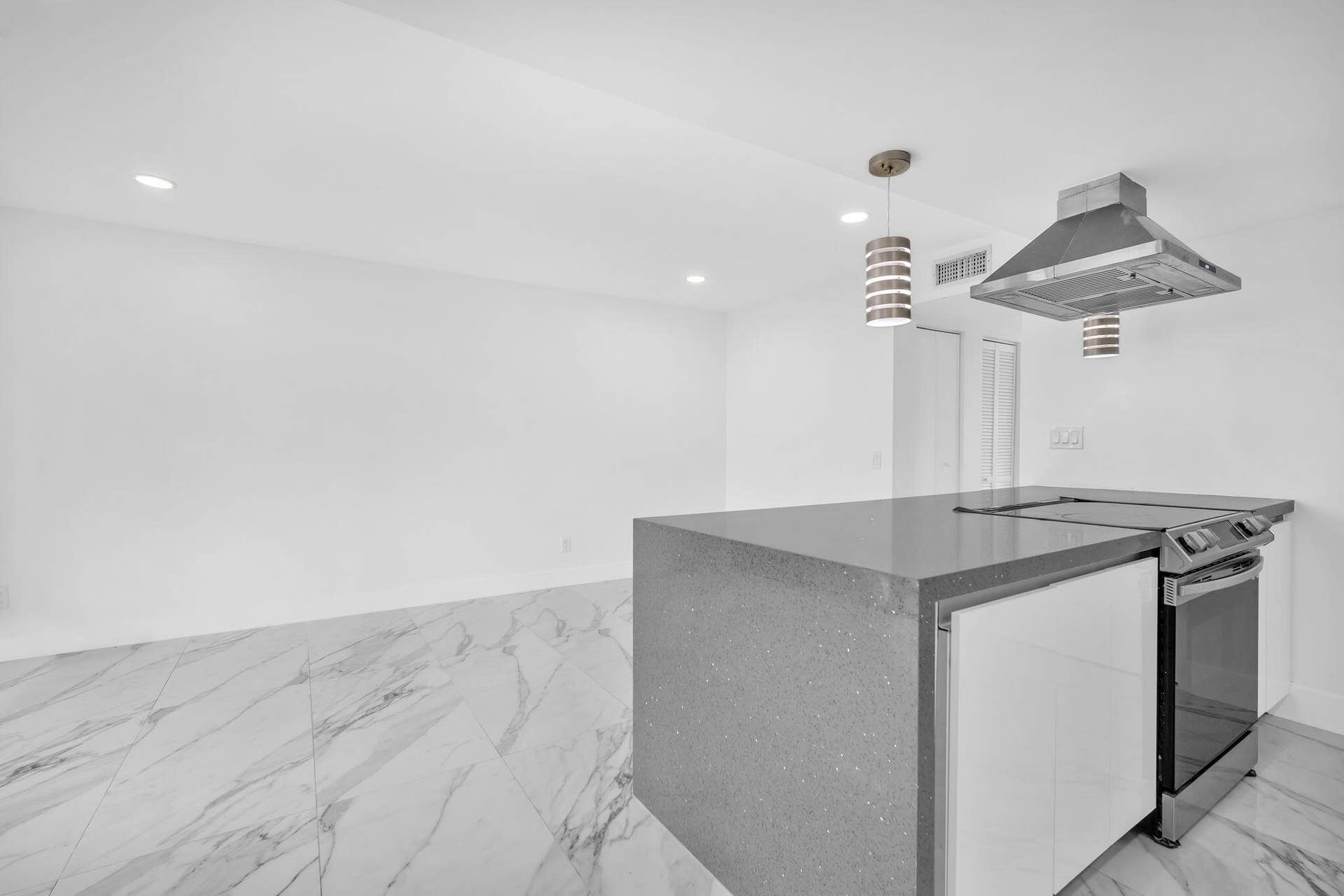 4162 SW 65th Avenue, #84, Davie, FL 33314 Kitchen featuring a central island with a solid surface countertop, high-gloss white cabinetry, stainless steel range, ceiling-mounted stainless steel vent hood, and large-format veined tile flooring