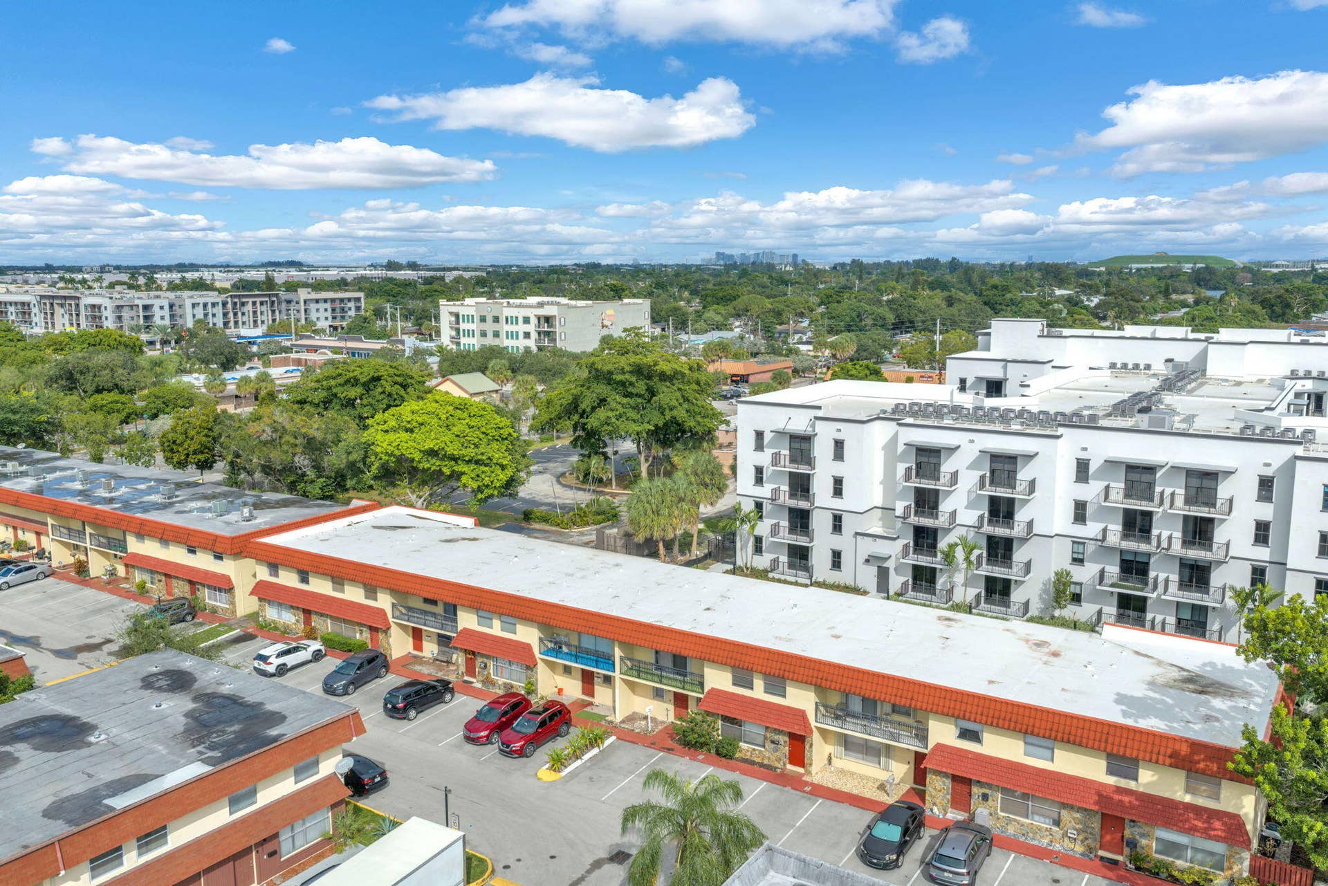 4162 SW 65th Avenue, #84, Davie, FL 33314 Aerial perspective of a multi-unit complex featuring terra-cotta style roofing, exterior staircases, integrated balconies, and designated surface parking