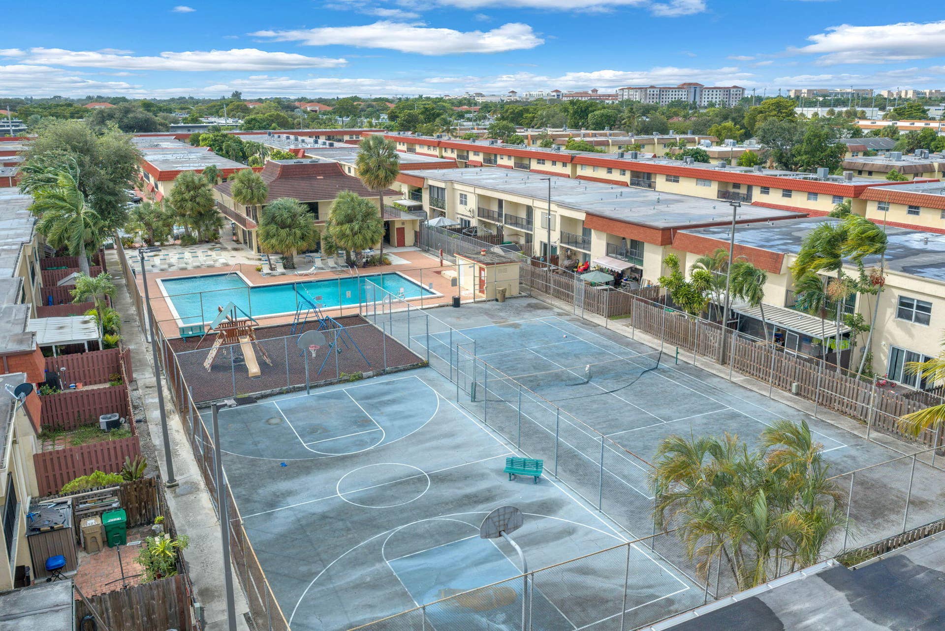 4162 SW 65th Avenue, #84, Davie, FL 33314 Community recreation area featuring a swimming pool, fenced basketball court, tennis court, and play structure