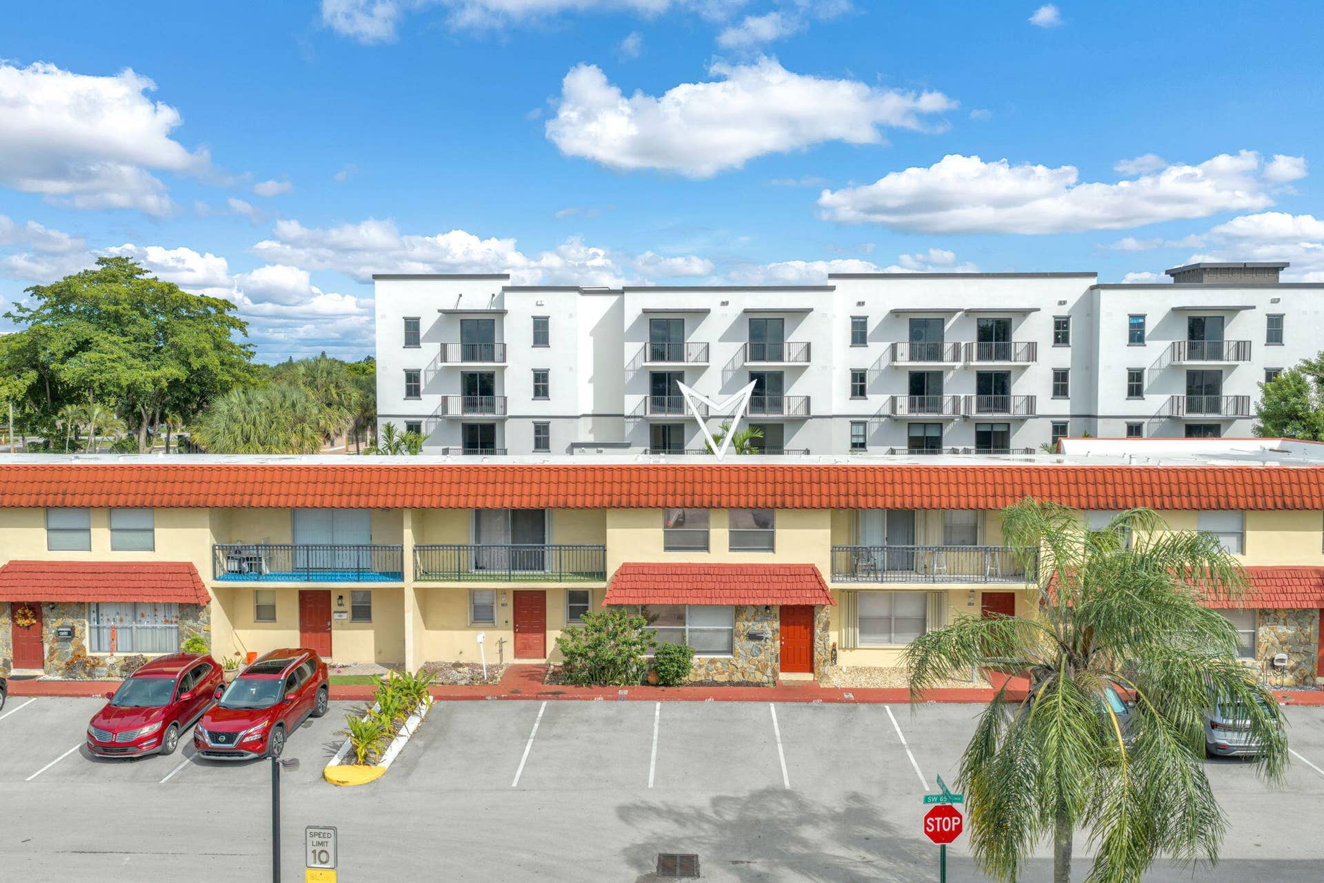 4162 SW 65th Avenue, #84, Davie, FL 33314 Two-story building exterior featuring a tiled roof, stone-accented facade, and balconies with metal railings