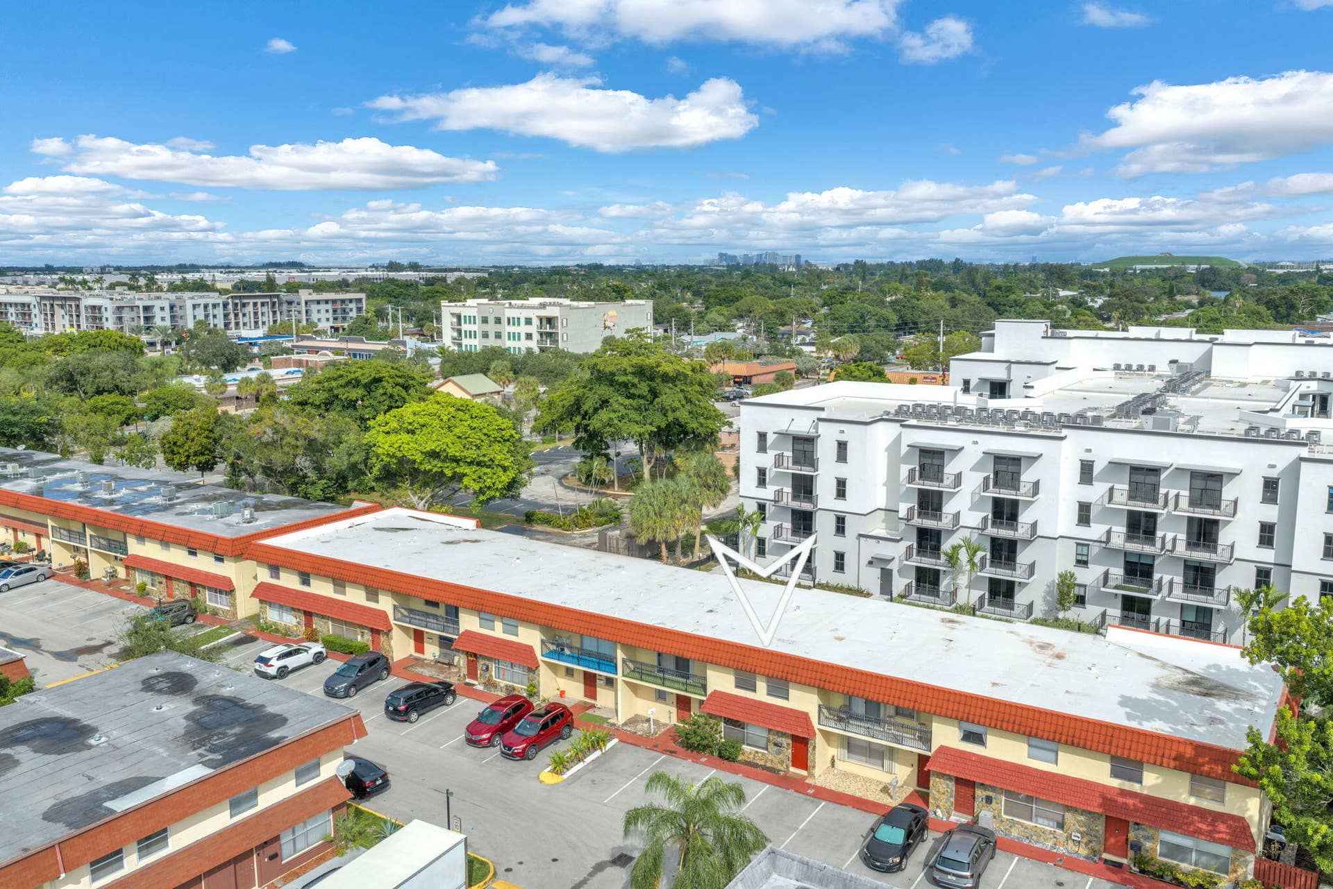 4162 SW 65th Avenue, #84, Davie, FL 33314 Exterior view of a multi-story residential building featuring a flat roof with tile accents, private balconies, and dedicated surface parking