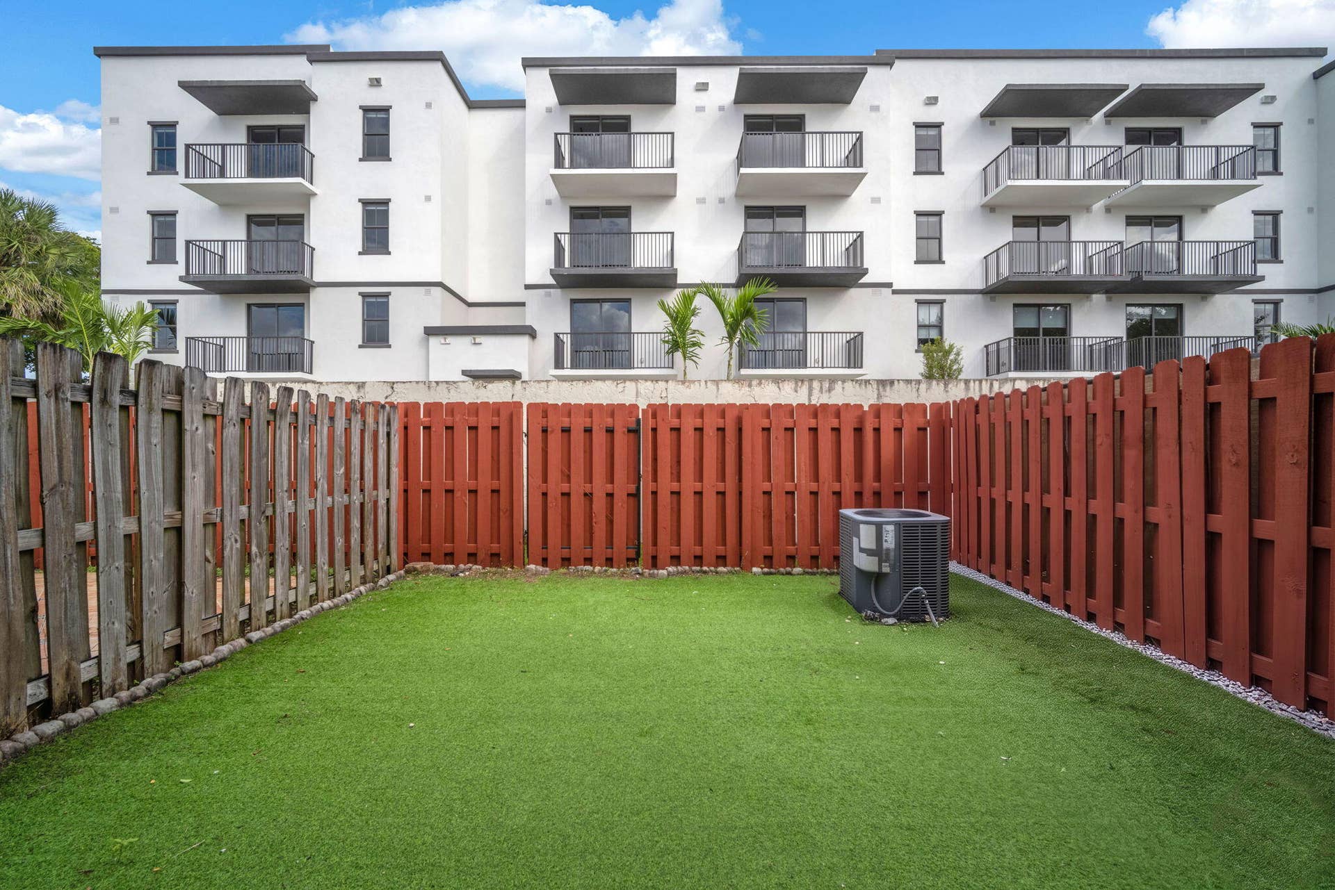 4162 SW 65th Avenue, #84, Davie, FL 33314 Fenced backyard featuring synthetic turf, wood privacy fencing, and an exterior HVAC unit