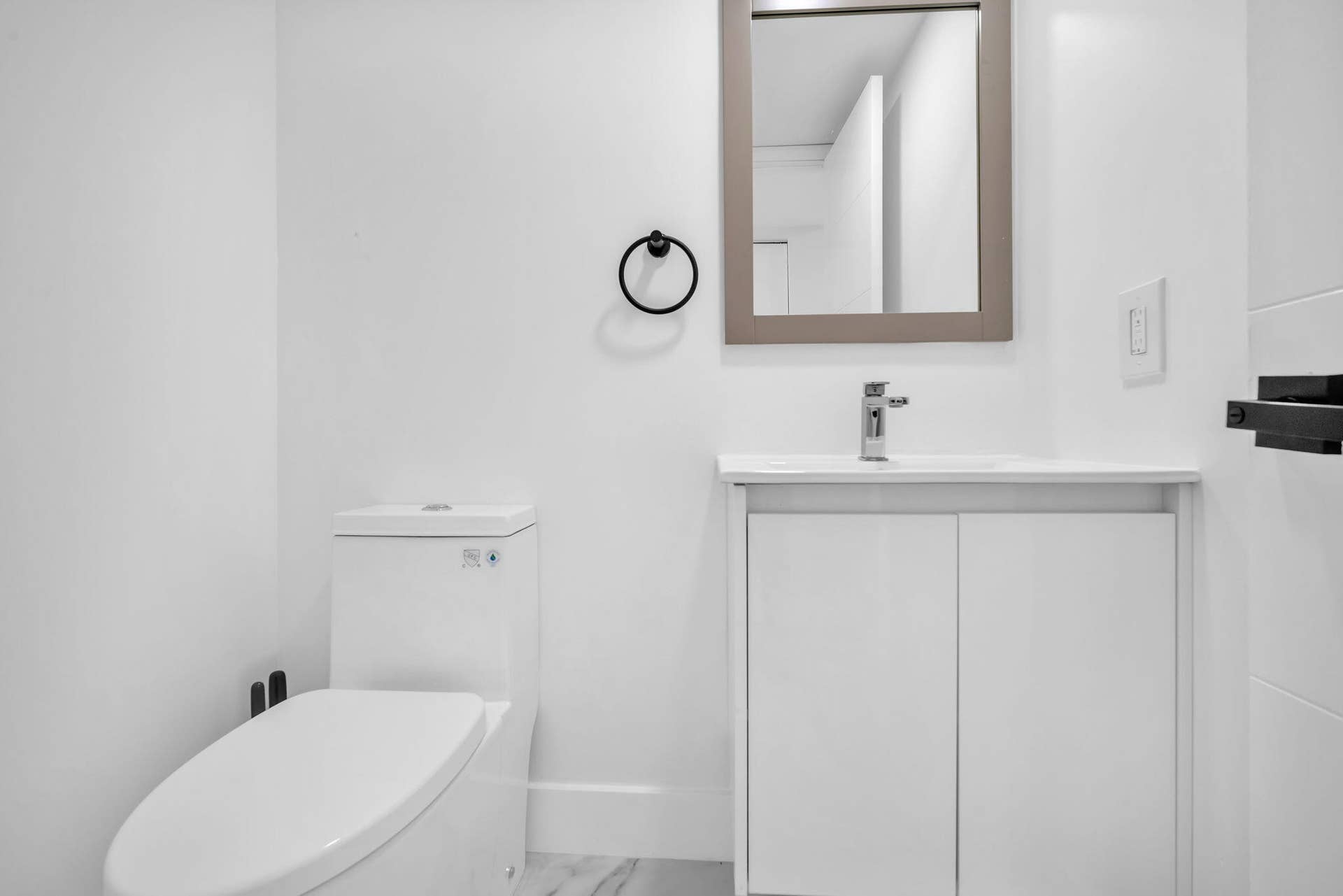 4162 SW 65th Avenue, #84, Davie, FL 33314 Bathroom featuring a white vanity cabinet, rectangular countertop sink, wall-mounted circular towel ring, and a framed mirror