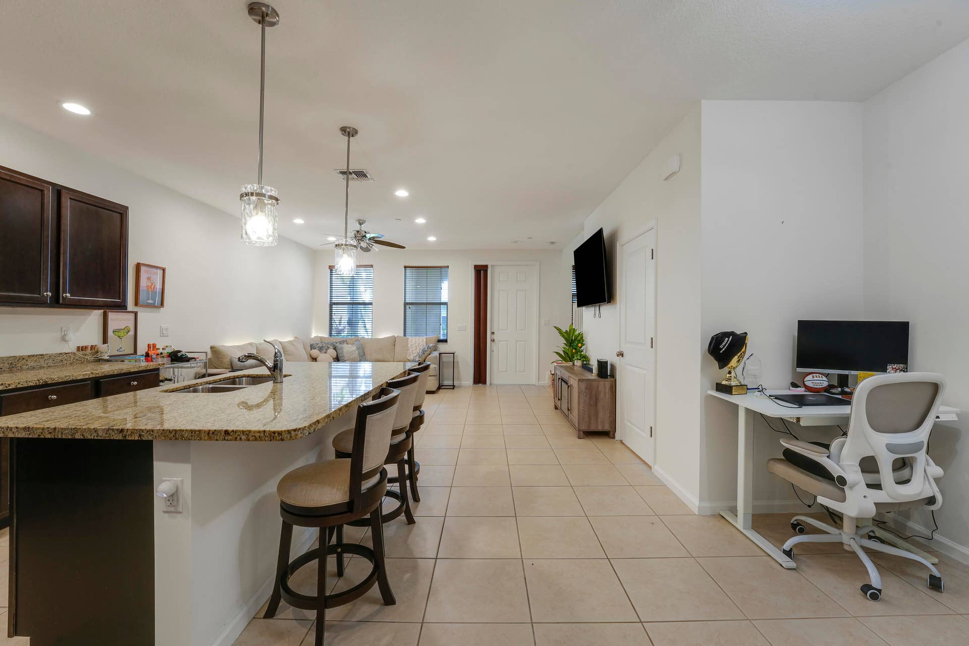 4326 Cascada Circle, Hollywood, FL 33024 Kitchen featuring dark cabinetry, stone-surface countertops, central island with double-basin sink, pendant lighting, and tile flooring