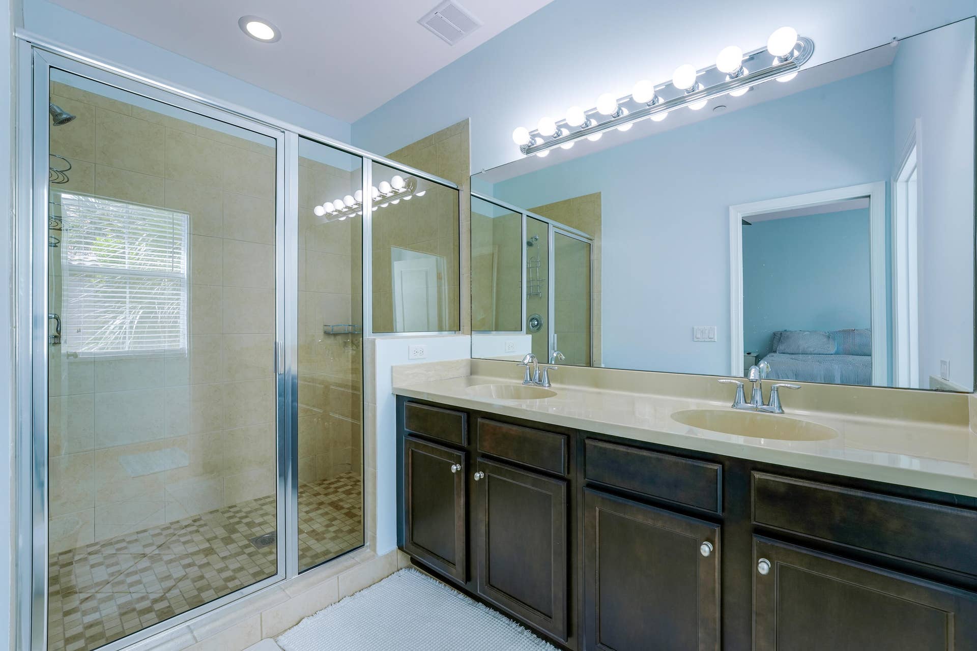 4326 Cascada Circle, Hollywood, FL 33024 Dual-sink vanity with a solid-surface countertop, floor-to-ceiling mirror, recessed lighting, and a walk-in glass-enclosed shower featuring tile flooring