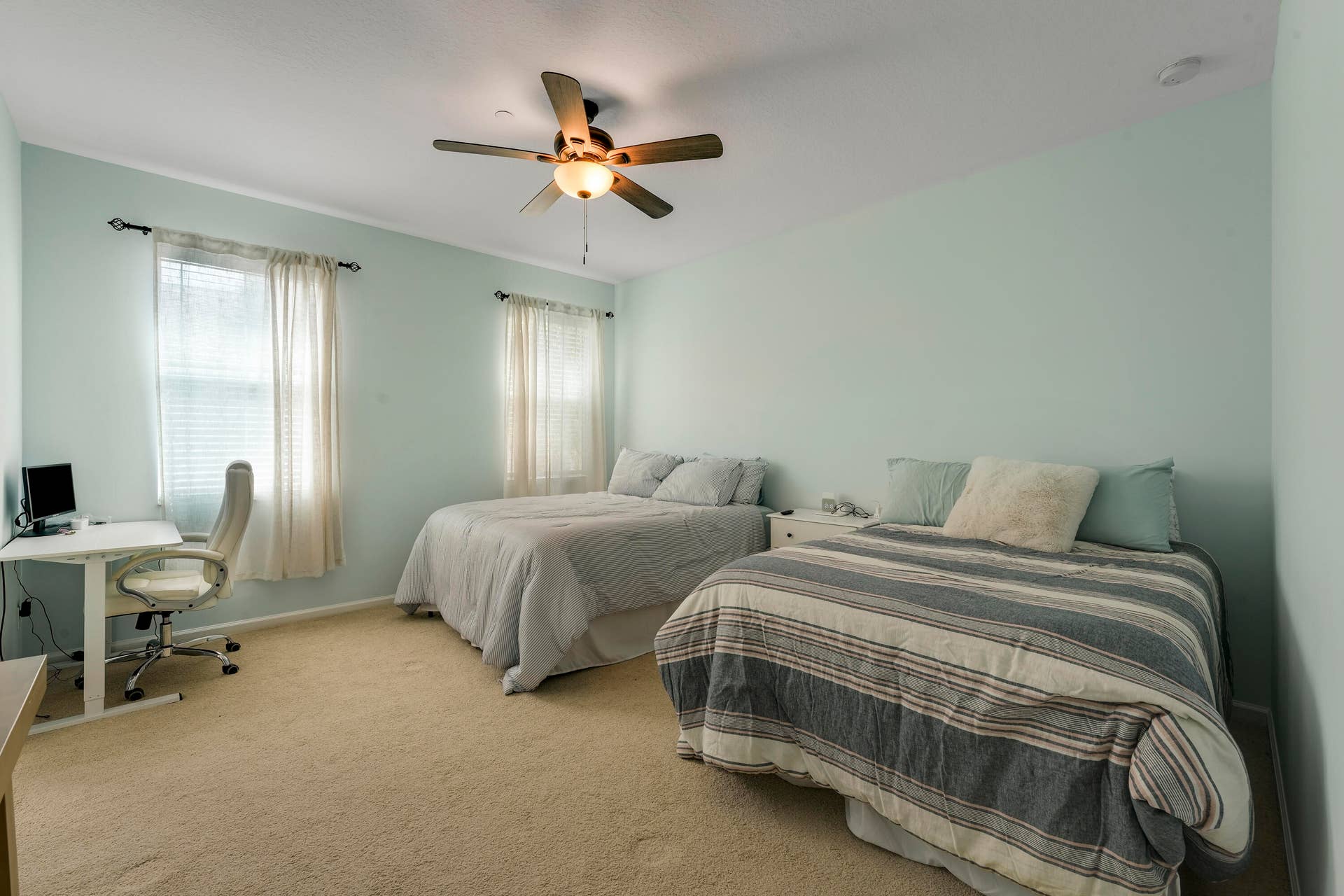4326 Cascada Circle, Hollywood, FL 33024 Neutral-toned interior featuring wall-to-wall carpeting, dual windows with installed curtain rods, and a ceiling fan with integrated lighting