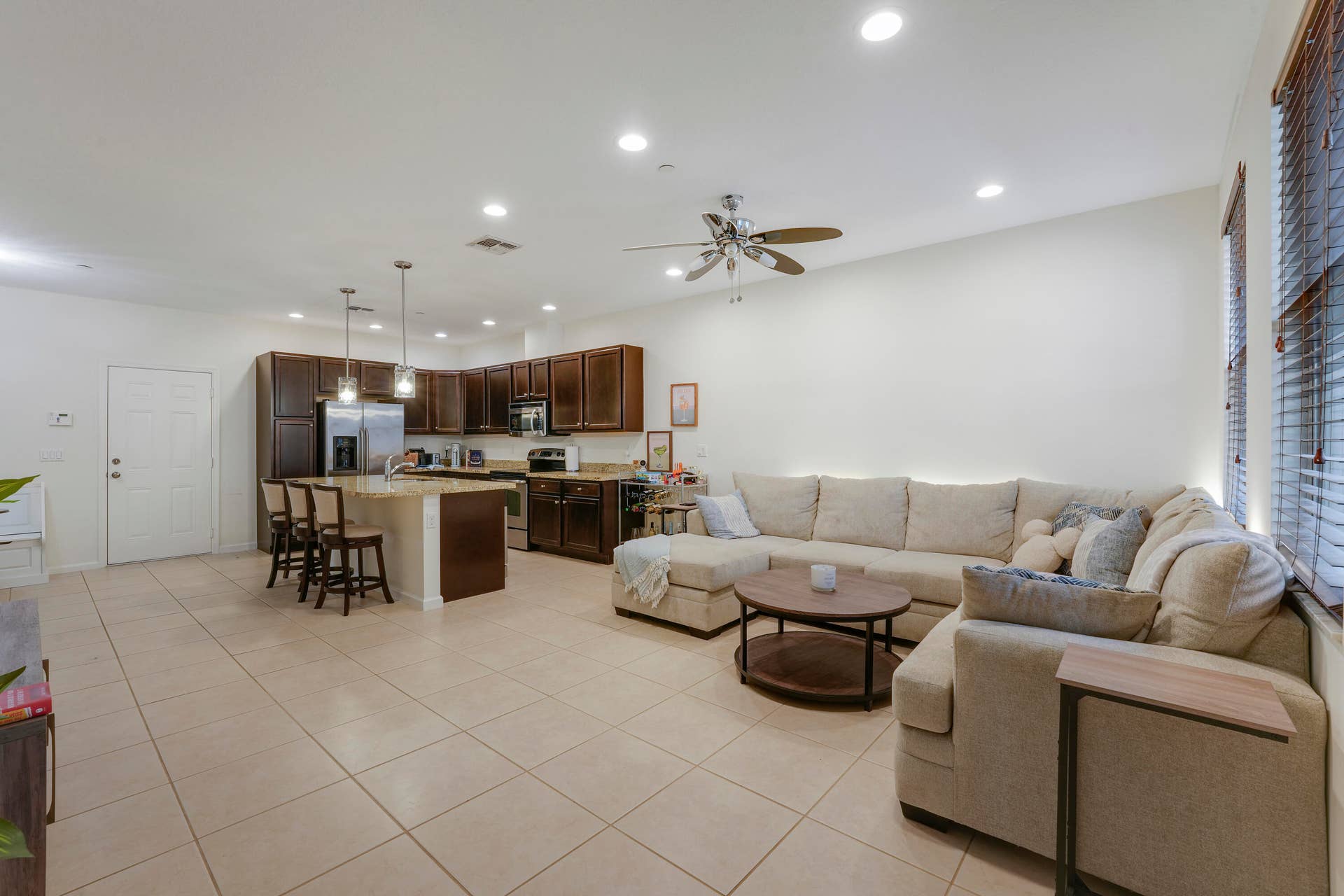 4326 Cascada Circle, Hollywood, FL 33024 Open-concept interior featuring large-format tile flooring, recessed ceiling lighting, kitchen island with stone countertop, dark wood cabinetry, and a ceiling fan