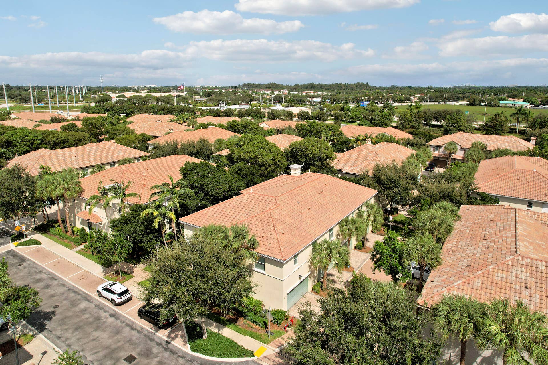 4326 Cascada Circle, Hollywood, FL 33024 Aerial perspective of multi-unit residential complex featuring terracotta-style roof tiles, light-toned stucco facades, paver-stone driveways, and mature palms and shade trees throughout the grounds