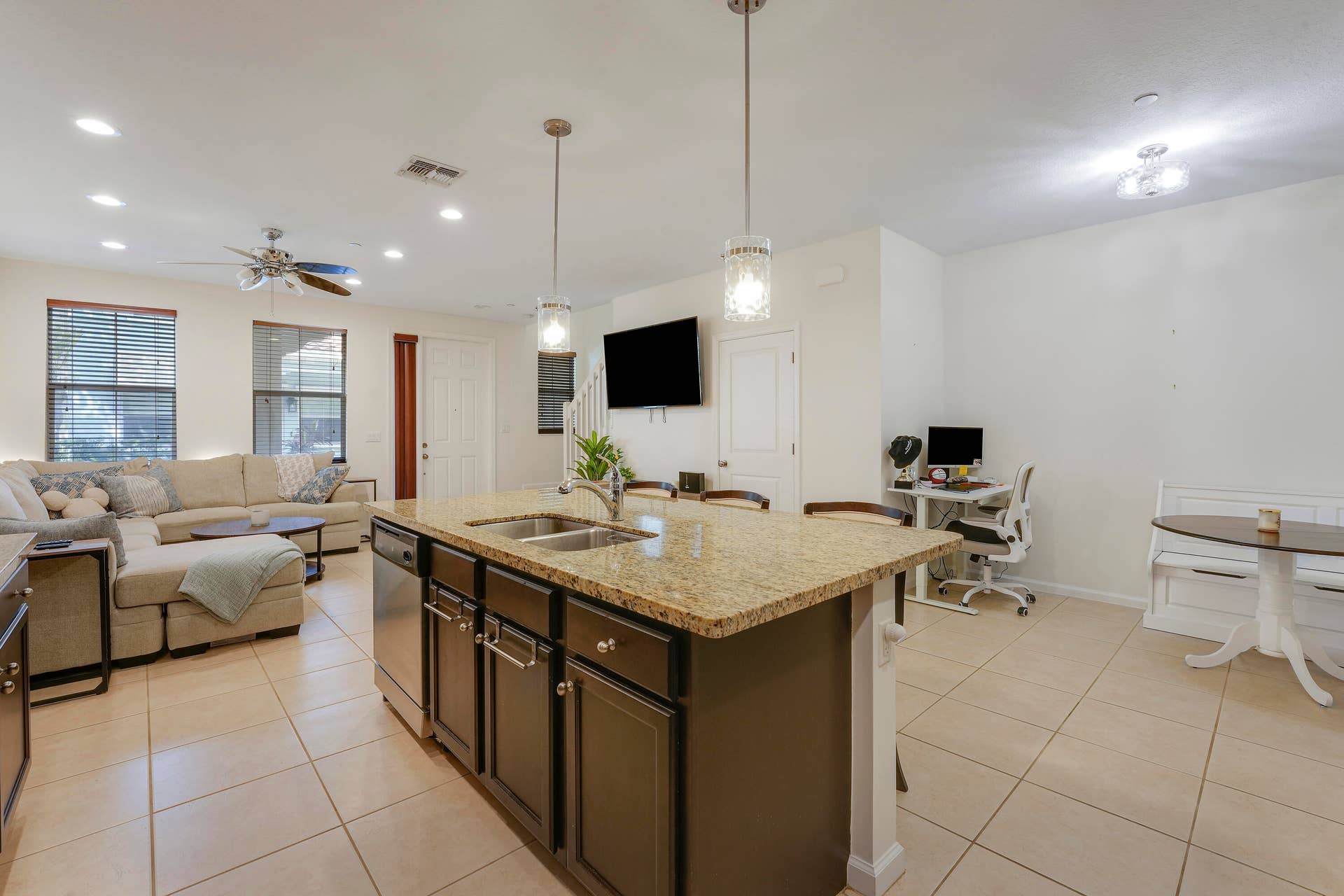 4326 Cascada Circle, Hollywood, FL 33024 Kitchen featuring a central island with a stone countertop, dual-basin stainless steel sink, dark-finish cabinetry, stainless steel dishwasher, and dual pendant lighting