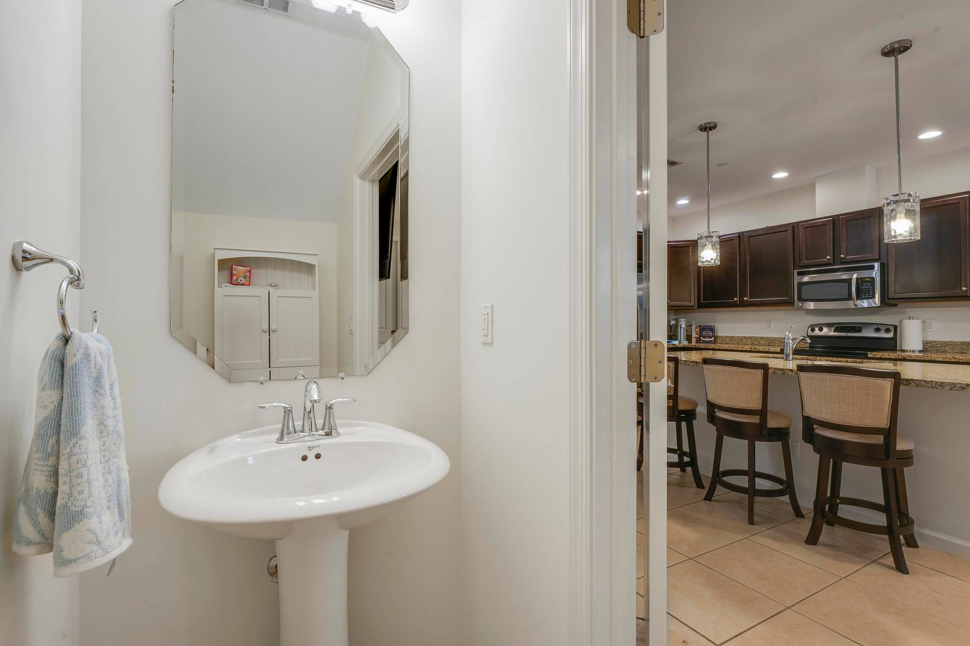 4326 Cascada Circle, Hollywood, FL 33024 Powder room featuring a pedestal sink, polished chrome faucet, and beveled-edge mirror