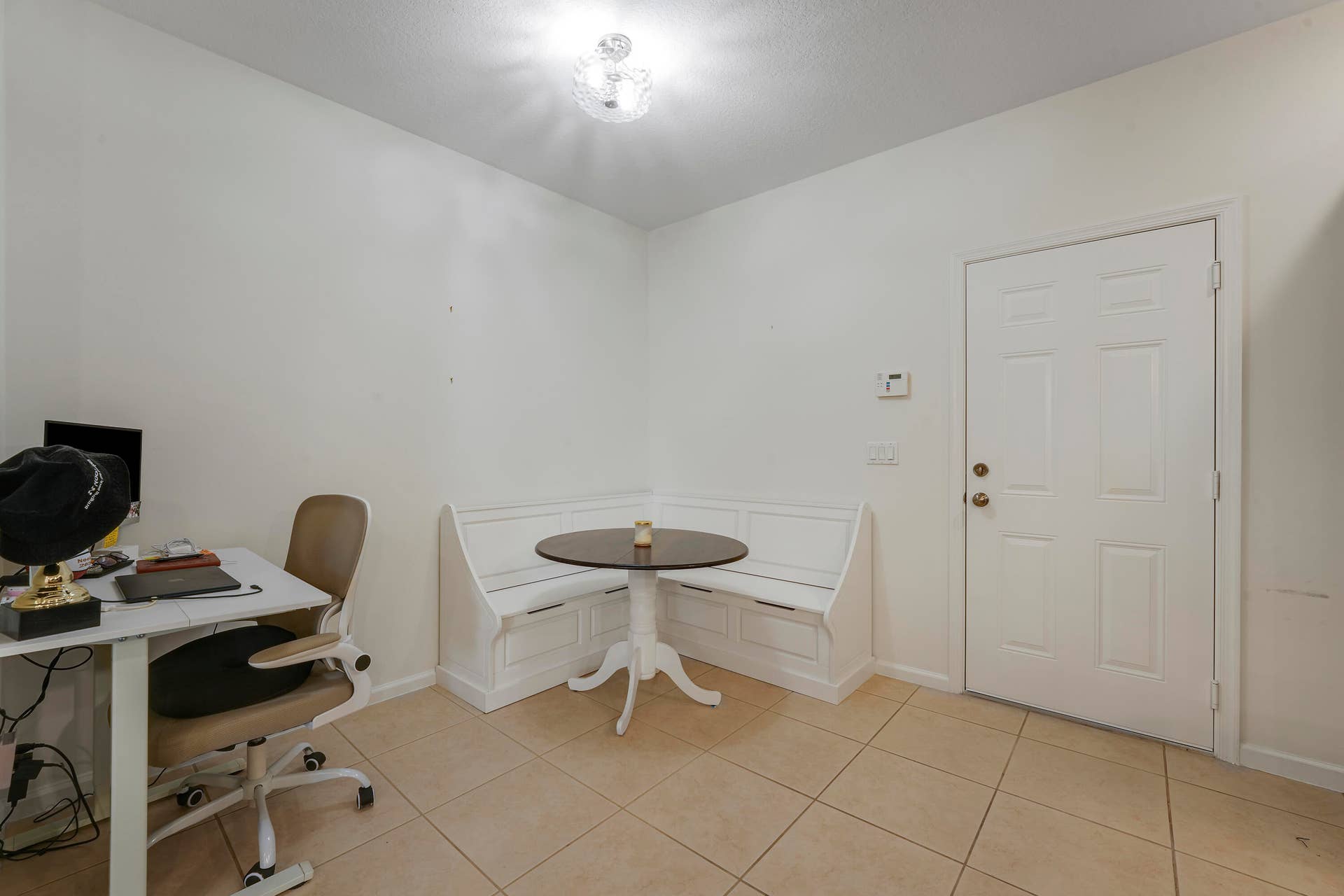 4326 Cascada Circle, Hollywood, FL 33024 Built-in white corner bench seating, neutral tile flooring, multi-panel entry door, and flush-mount ceiling light fixture