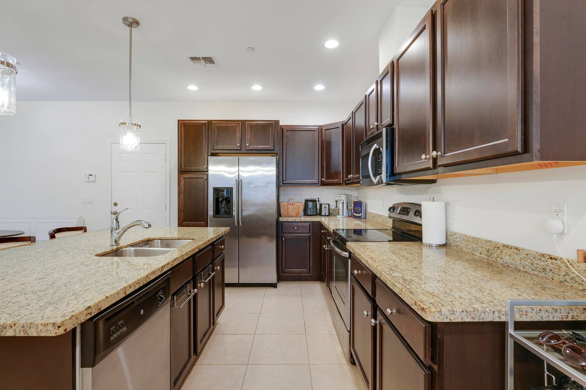 4326 Cascada Circle, Hollywood, FL 33024 Kitchen featuring dark-finish cabinetry, stone-surface countertops, stainless steel appliances, a center island with a dual-basin sink, and recessed lighting