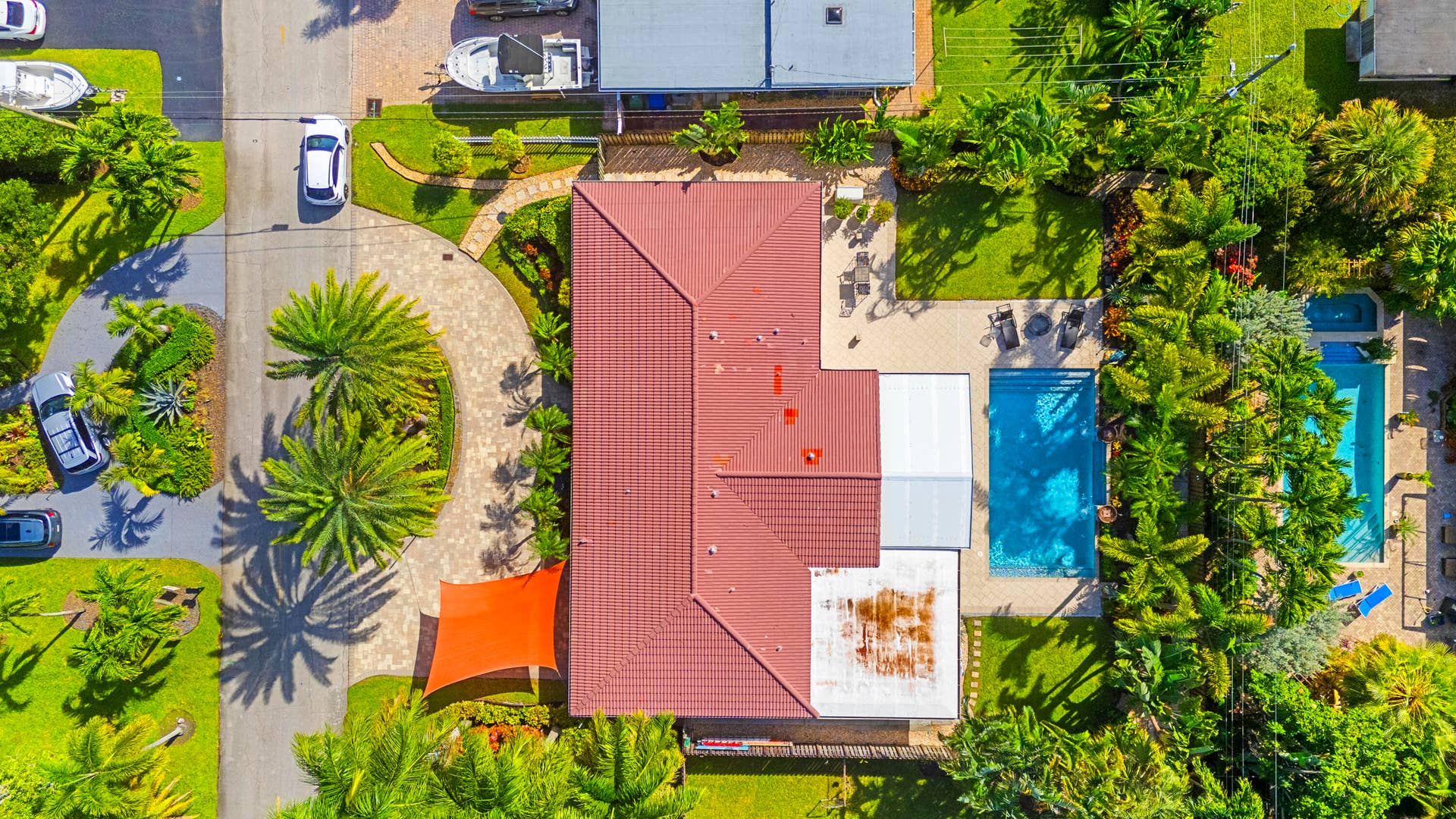 2317 NW 6th Avenue, Wilton Manors, FL 33311 Aerial perspective featuring a tile roof, paved circular driveway, swimming pool, and extensive mature landscaping