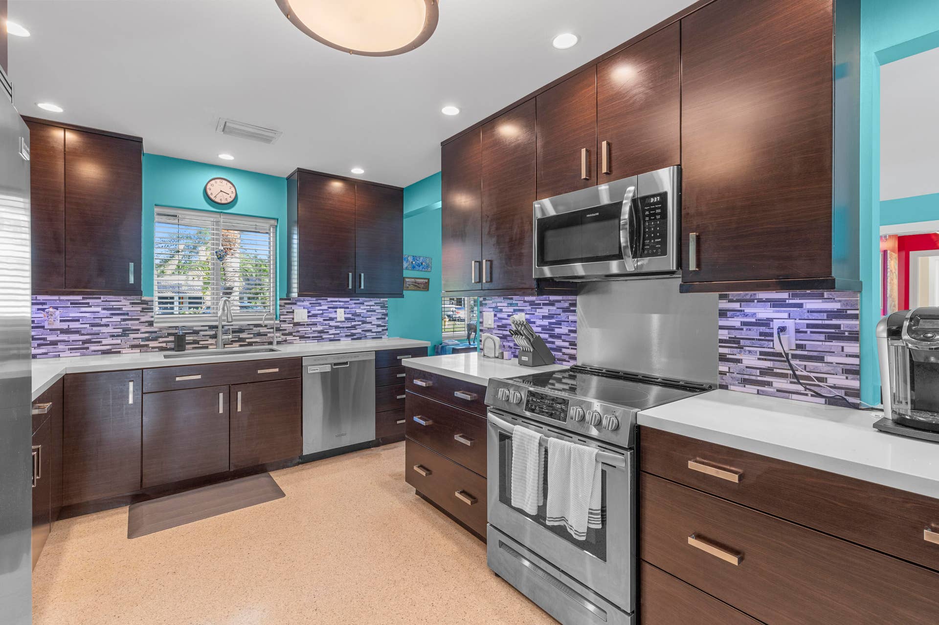 2317 NW 6th Avenue, Wilton Manors, FL 33311 Dark wood-finish cabinetry, stainless steel appliances, multi-colored glass tile backsplash, quartz countertops, and recessed lighting