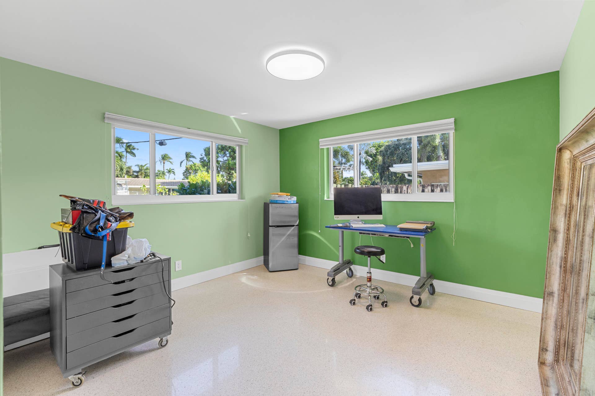 2317 NW 6th Avenue, Wilton Manors, FL 33311 Room featuring polished terrazzo flooring, two large sliding windows, and a ceiling-mounted flush-mount light fixture