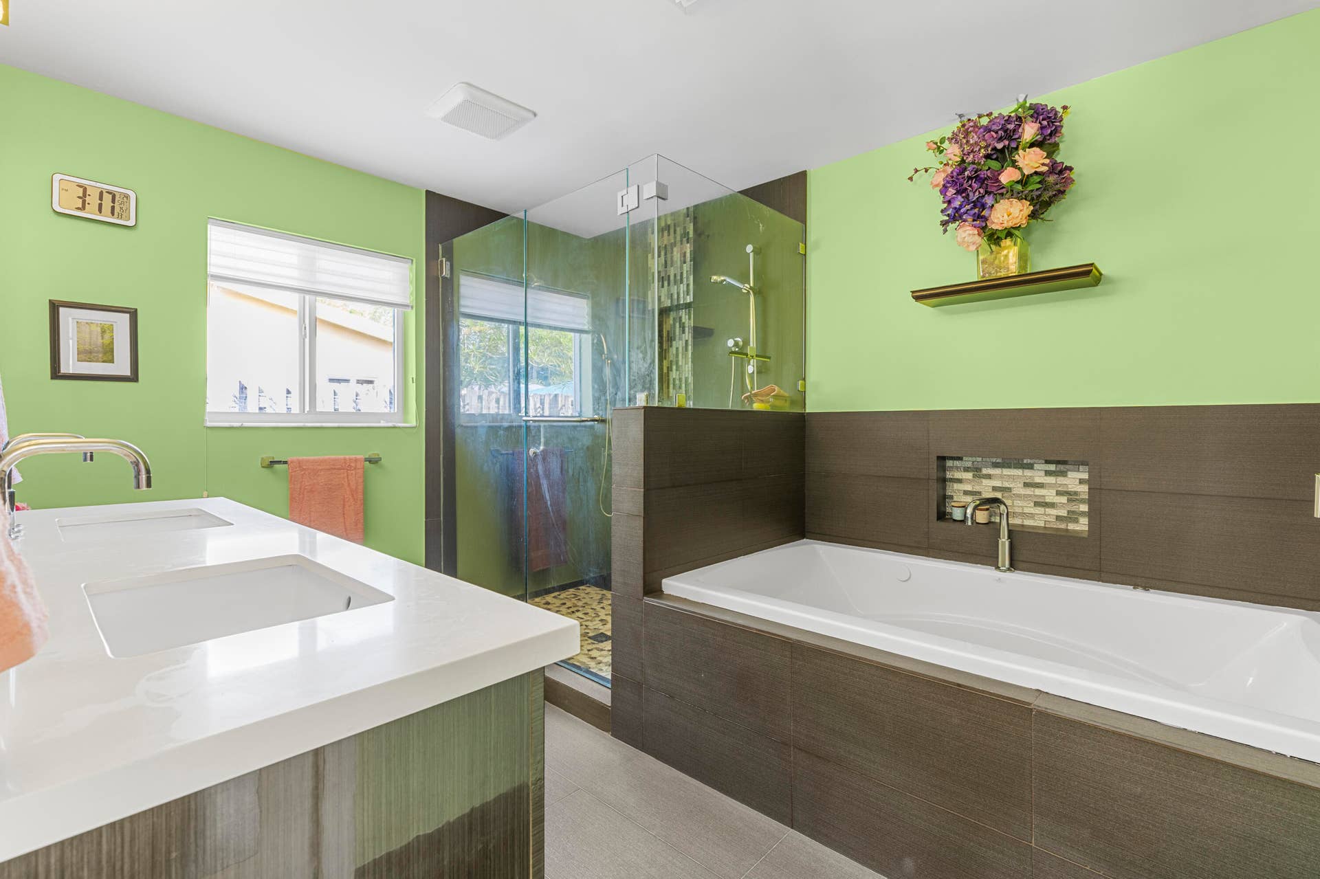 2317 NW 6th Avenue, Wilton Manors, FL 33311 Dual vanity with rectangular undermount sinks and white solid-surface countertops, walk-in shower with glass enclosure, and built-in soaking tub featuring a tiled niche and surround