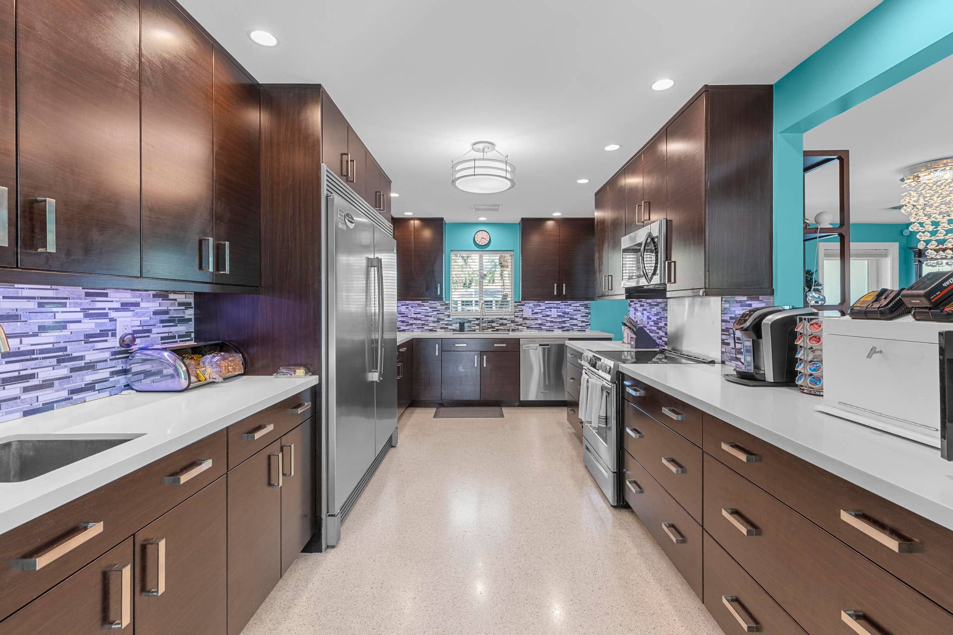 2317 NW 6th Avenue, Wilton Manors, FL 33311 Kitchen featuring dark wood cabinetry, light-toned solid surface countertops, a mosaic tile backsplash, stainless steel appliances, and recessed lighting
