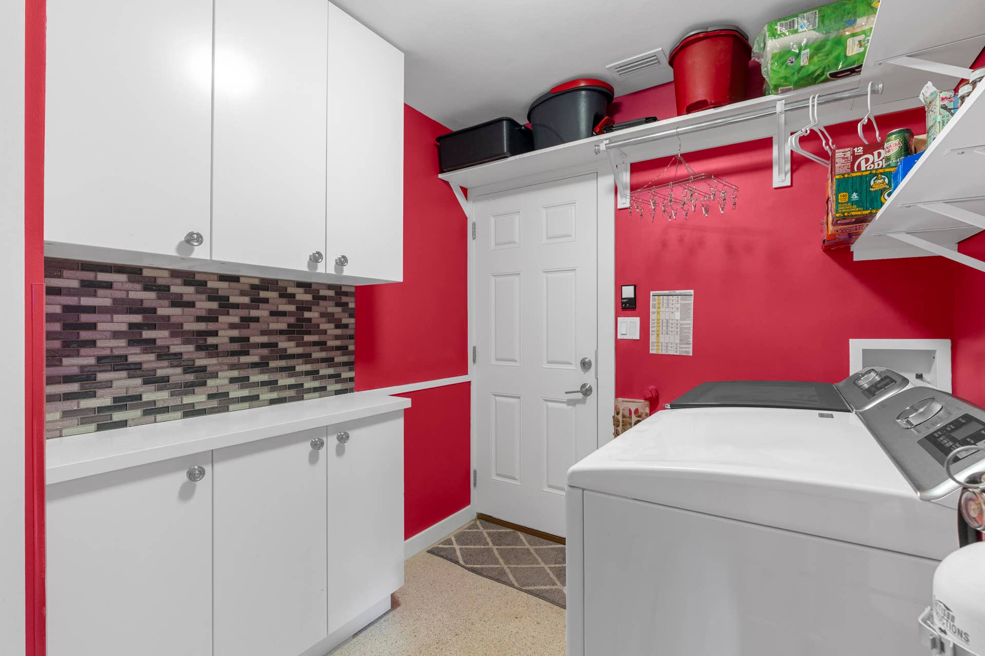2317 NW 6th Avenue, Wilton Manors, FL 33311 Laundry area featuring white cabinetry, a solid-surface countertop, decorative tile backsplash, and open shelving