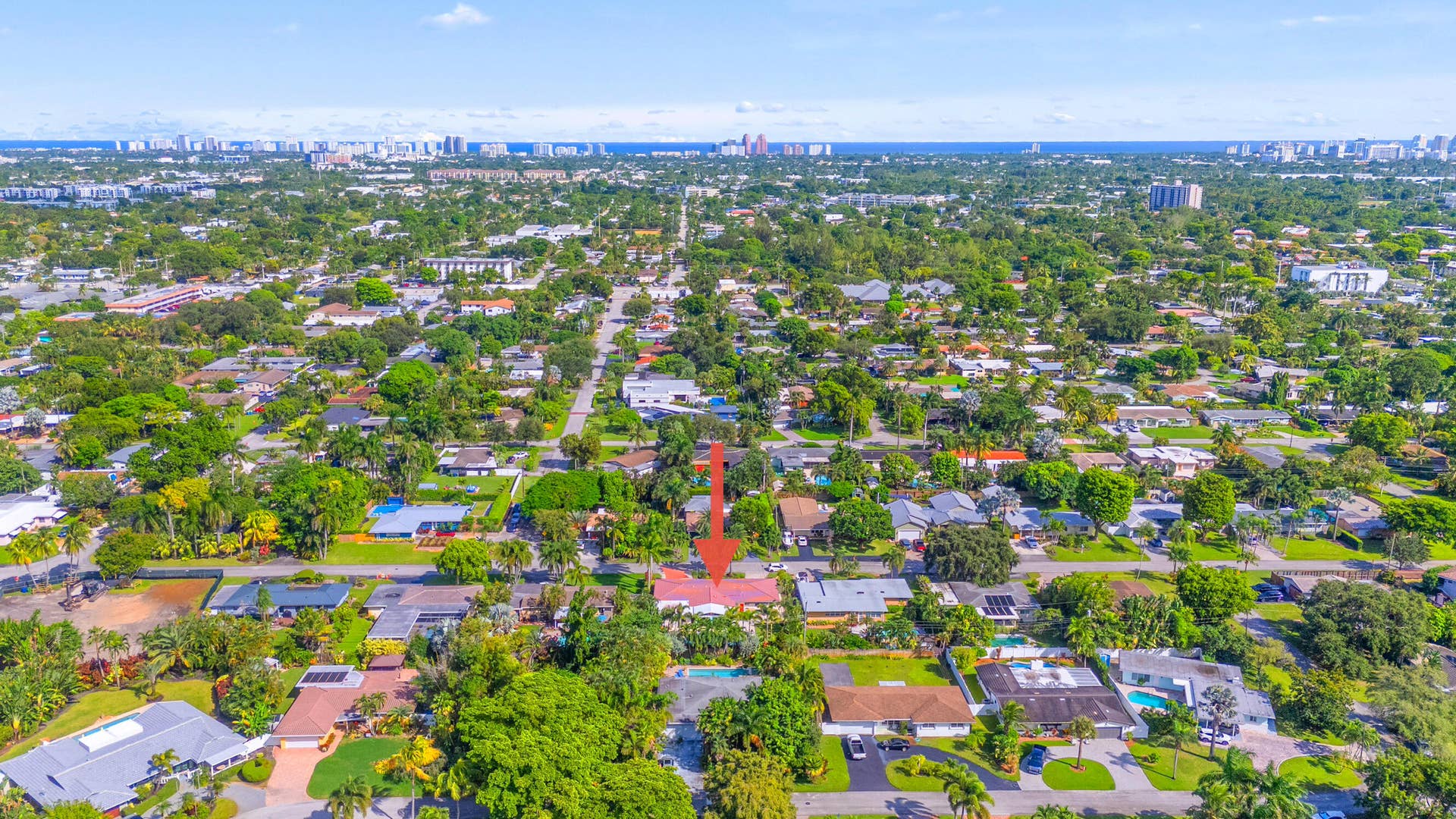 2317 NW 6th Avenue, Wilton Manors, FL 33311 Aerial perspective of property featuring a pitched roof, attached garage, private swimming pool, and dense perimeter landscaping