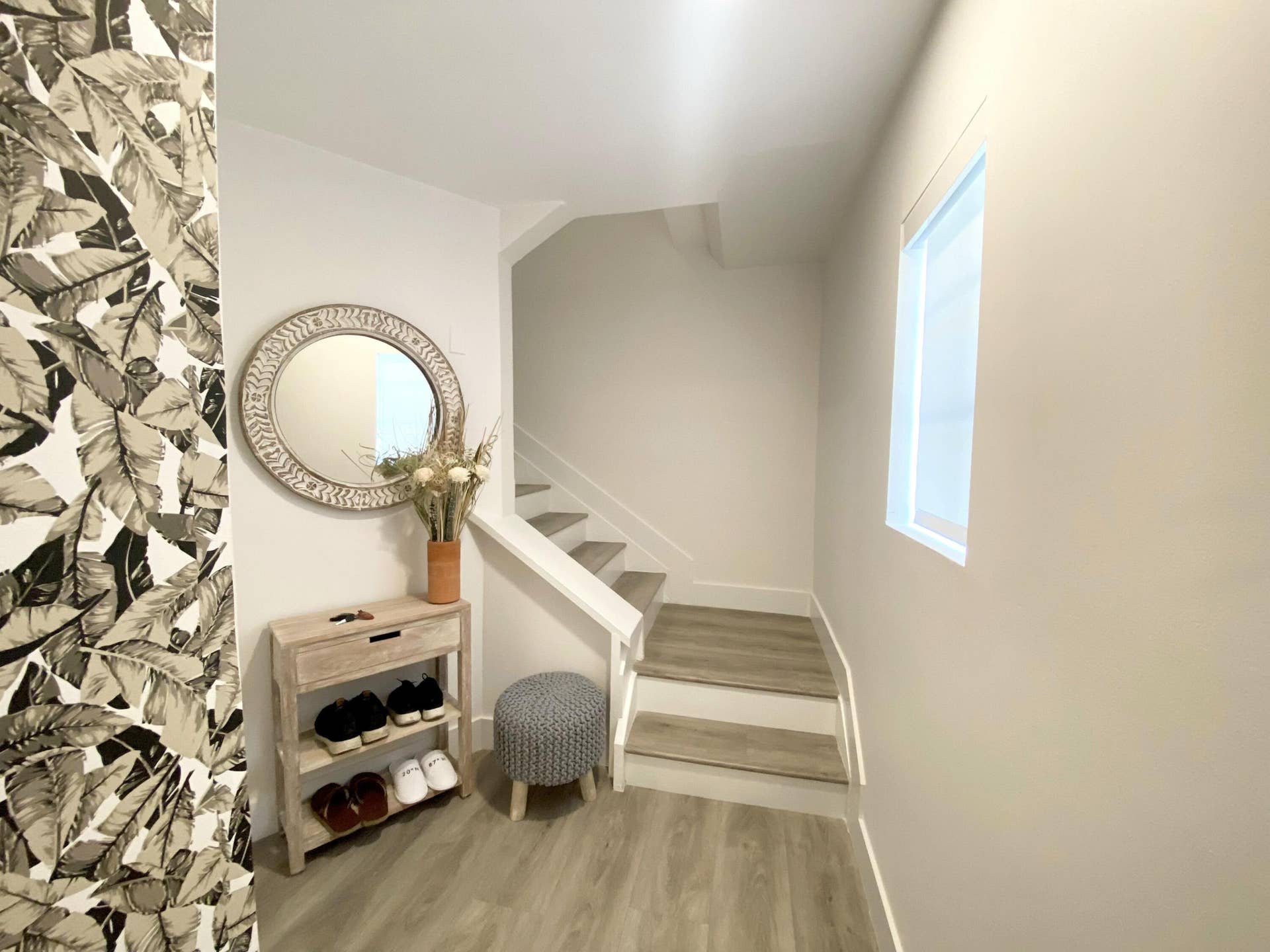 2941 NE 185TH Street, #1303, Aventura, FL 33180 Foyer featuring patterned wall covering, wood-finish flooring, a rectangular window, and a staircase with wood-finish treads