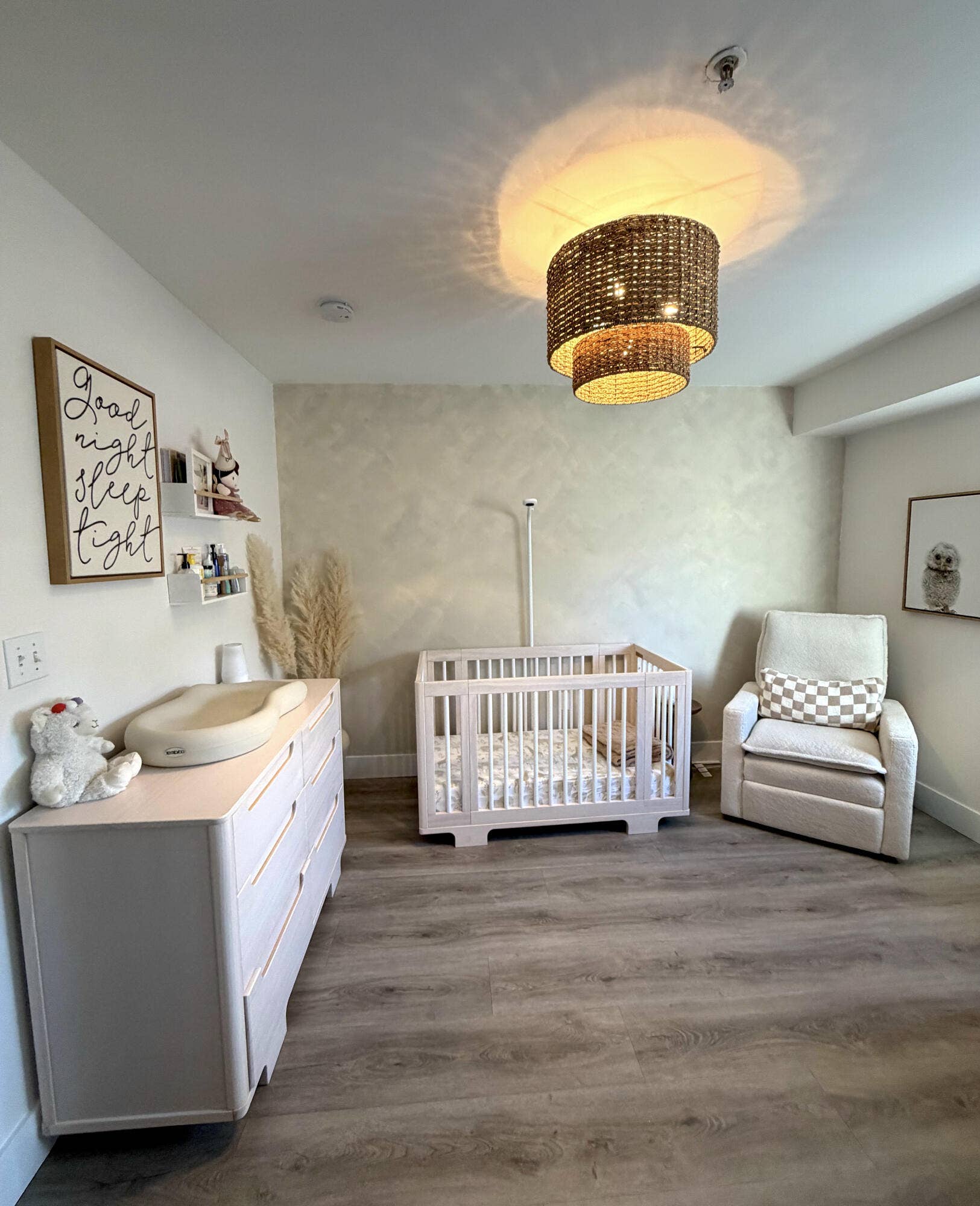 2941 NE 185TH Street, #1303, Aventura, FL 33180 Bedroom featuring wood-finish flooring, a textured accent wall, and a multi-tiered woven drum light fixture