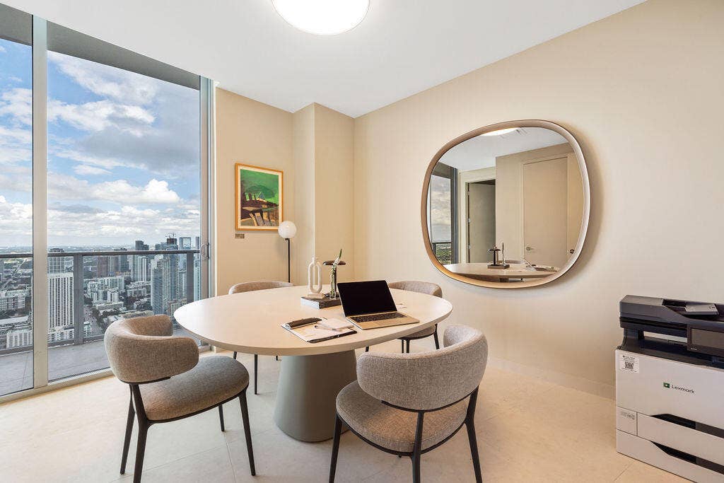 Floor-to-ceiling windows featuring panoramic urban scenery, neutral stone-finish flooring, and recessed ceiling lighting