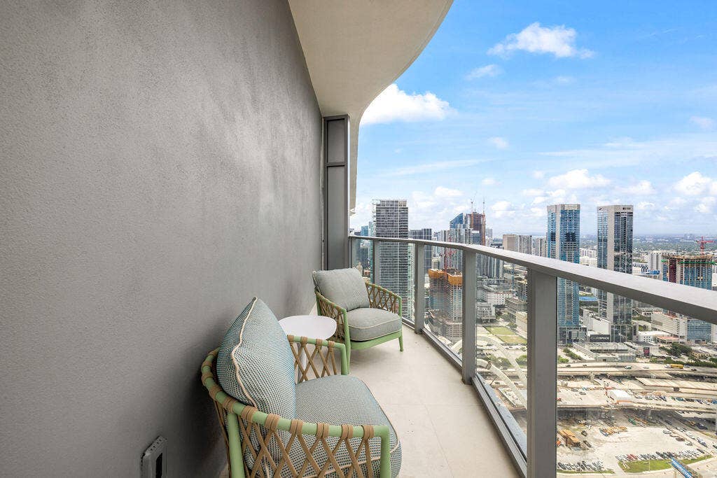 Covered balcony featuring a concrete floor, a solid exterior wall, and a metal railing with glass panels