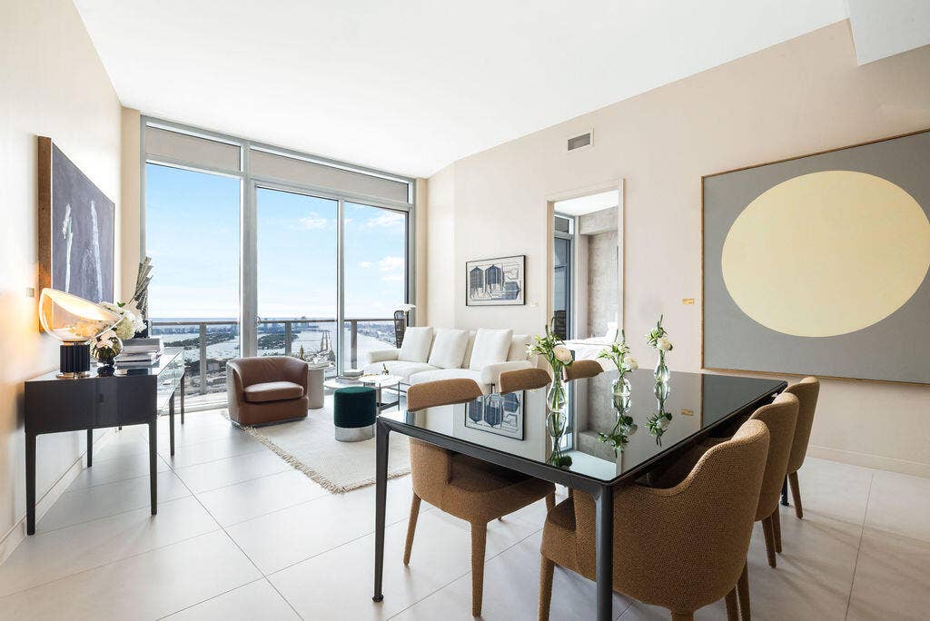 Open-concept living space featuring floor-to-ceiling windows, porcelain tile flooring, and a private balcony