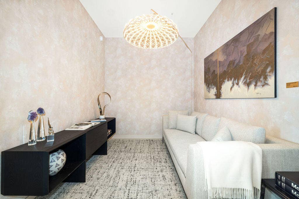 Textured neutral wall treatments, patterned wall-to-wall carpeting, and a geometric pendant light fixture