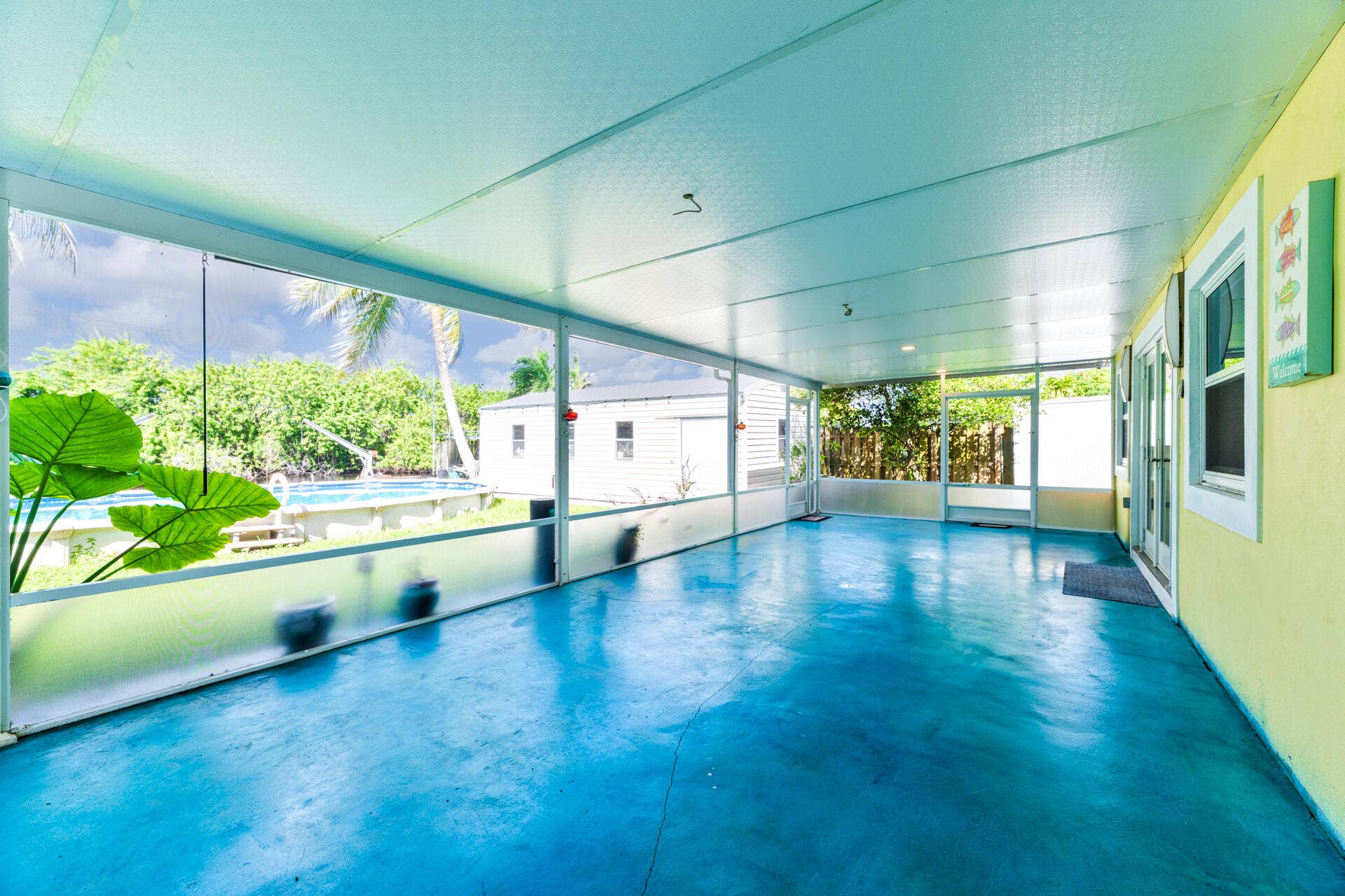 Screened-in porch featuring a solid-surface floor, recessed lighting, and multiple door access