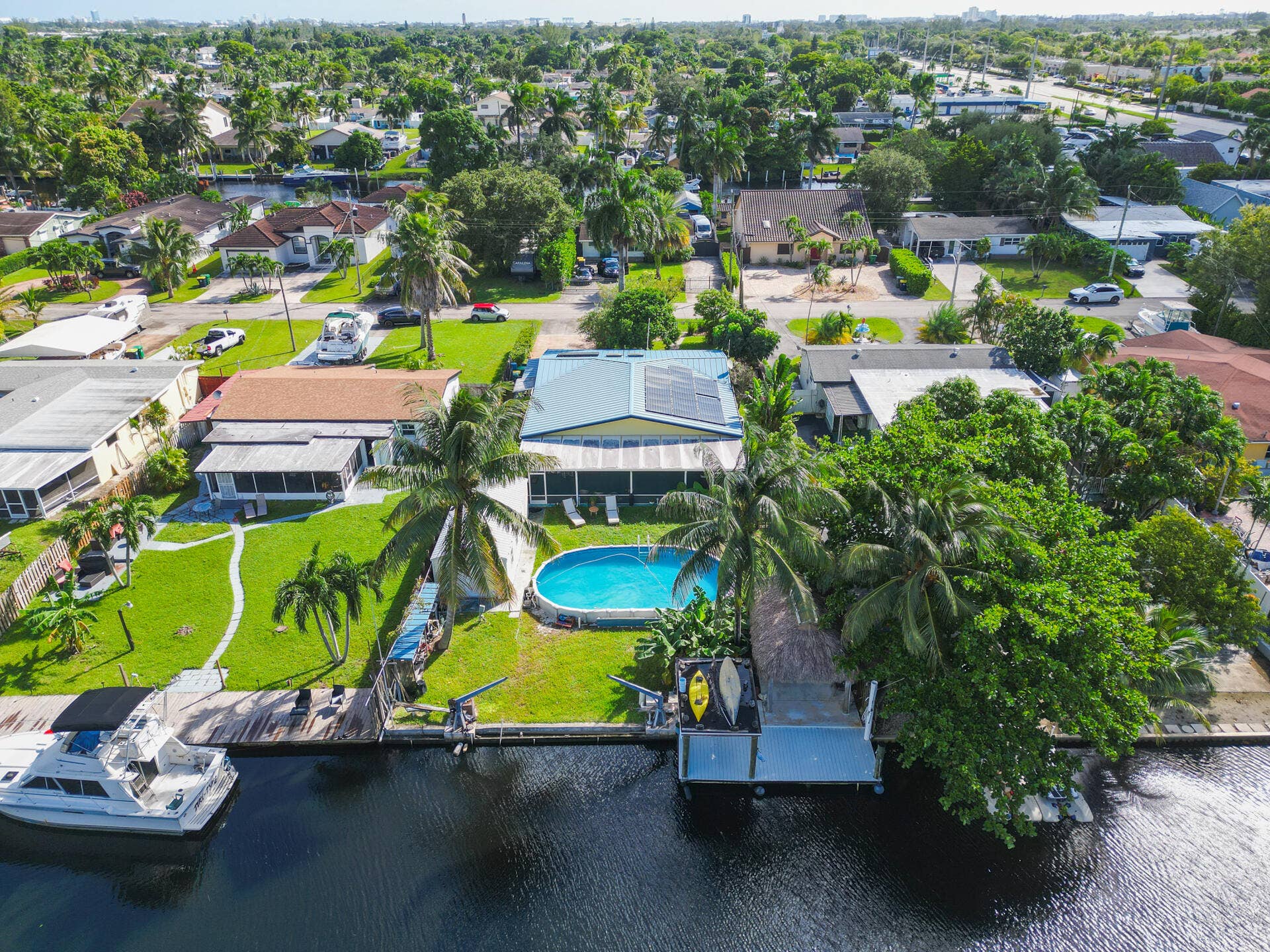 Waterfront property featuring a private boat dock, in-ground swimming pool, 28 solar panel array, and expansive canal frontage