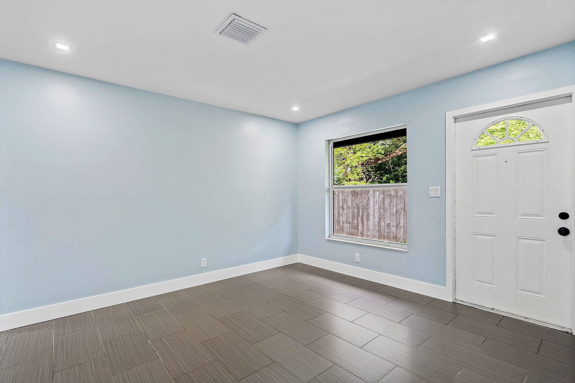 1211 NE 2nd Avenue, Fort Lauderdale, FL 33304 Room featuring neutral wall paint, tile flooring, recessed lighting, and a single-hung window with a metal-frame exterior door