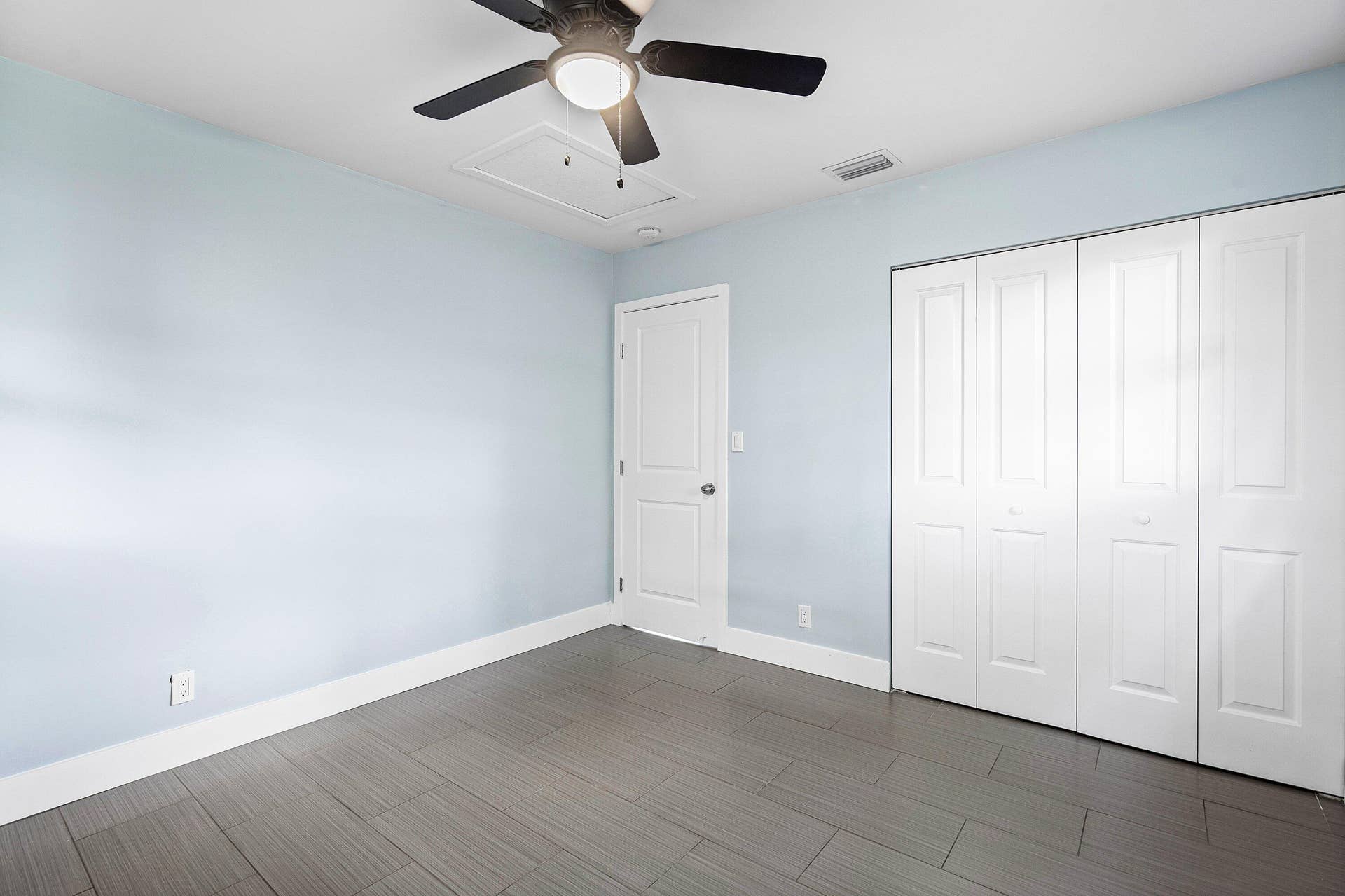 1211 NE 2nd Avenue, Fort Lauderdale, FL 33304 Room featuring large-format tile flooring, a multi-panel door, built-in closet with folding doors, and a ceiling-mounted light fixture with fan