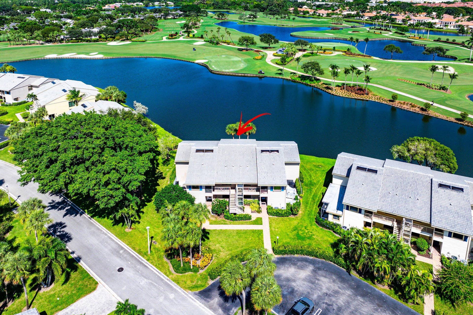 Multi-level residence featuring a composite shingle roof, integrated balcony structures, and direct waterfront placement