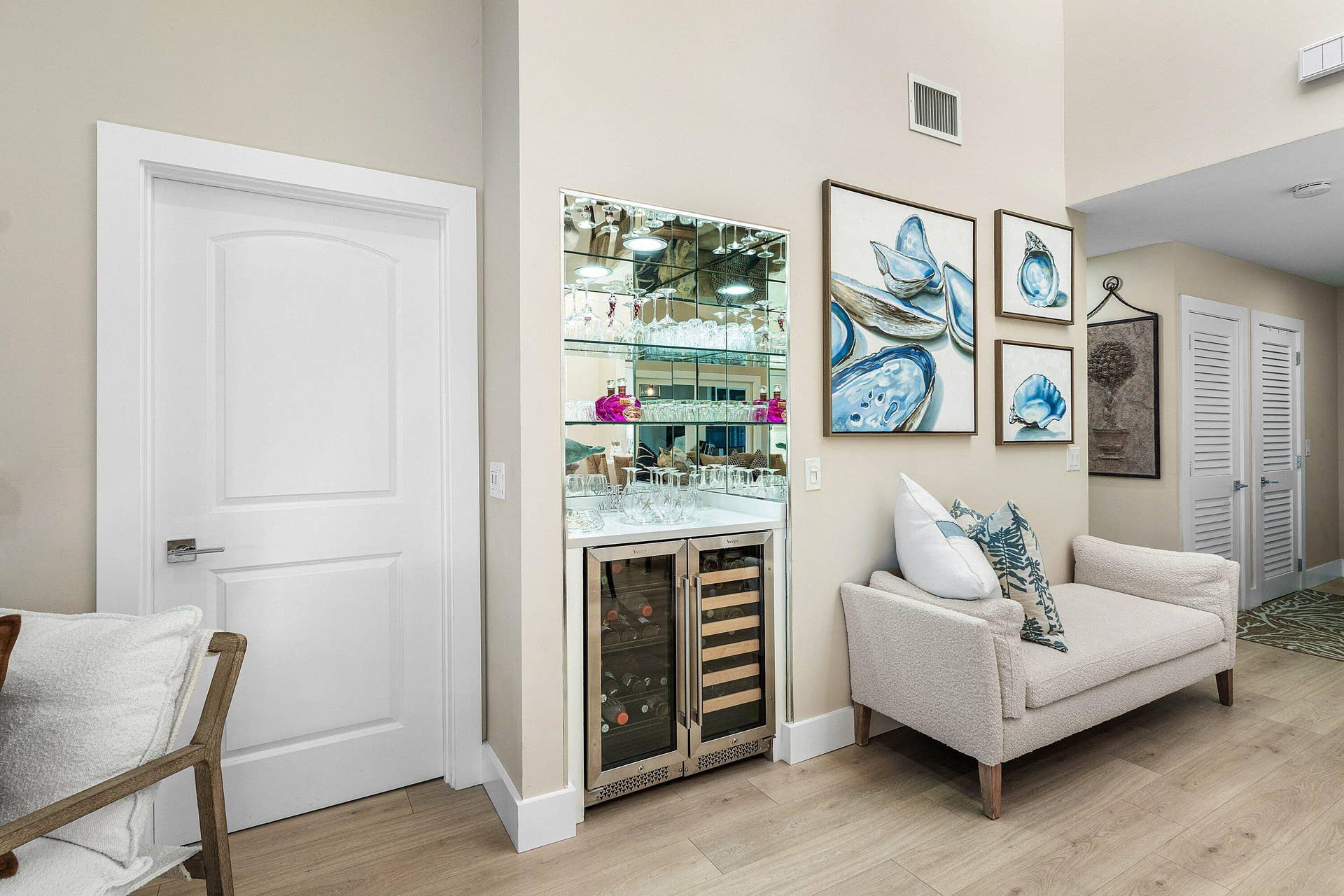 Built-in wet bar featuring mirrored shelving, glass cabinetry, stone countertop, and dual-zone stainless steel wine refrigerator